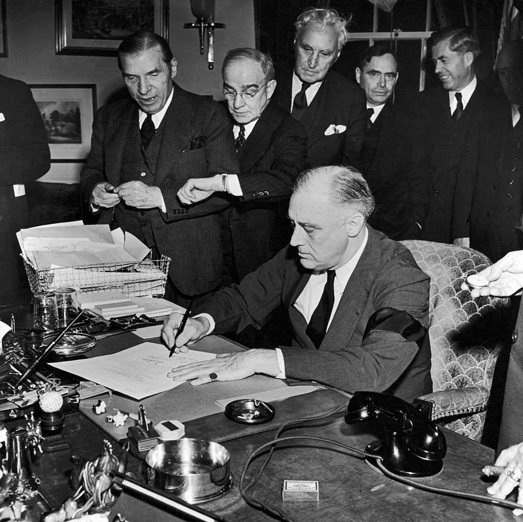 President Franklin D. Roosevelt (wearing black armband) signing declaration of war as others look on, following Japanese bombing of Pearl Harbor. (Thomas D. Mcavoy/The LIFE Picture Collection—Getty Images)