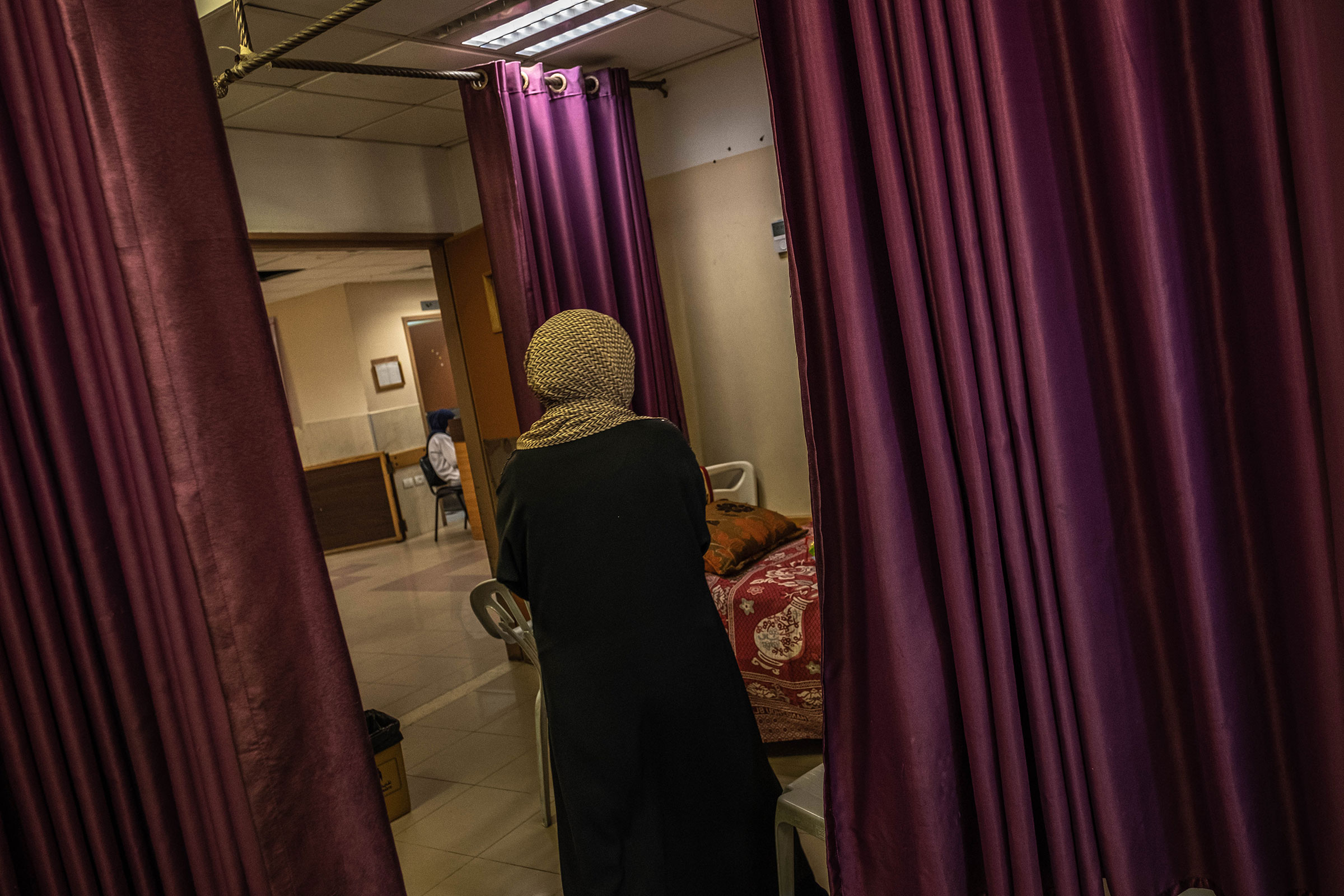 Drapes hang as Palestinians, who were wounded in overnight Israeli air strikes on the Gaza Strip, receives treatment at Al-Shifa Hospital on May 18, 2021.