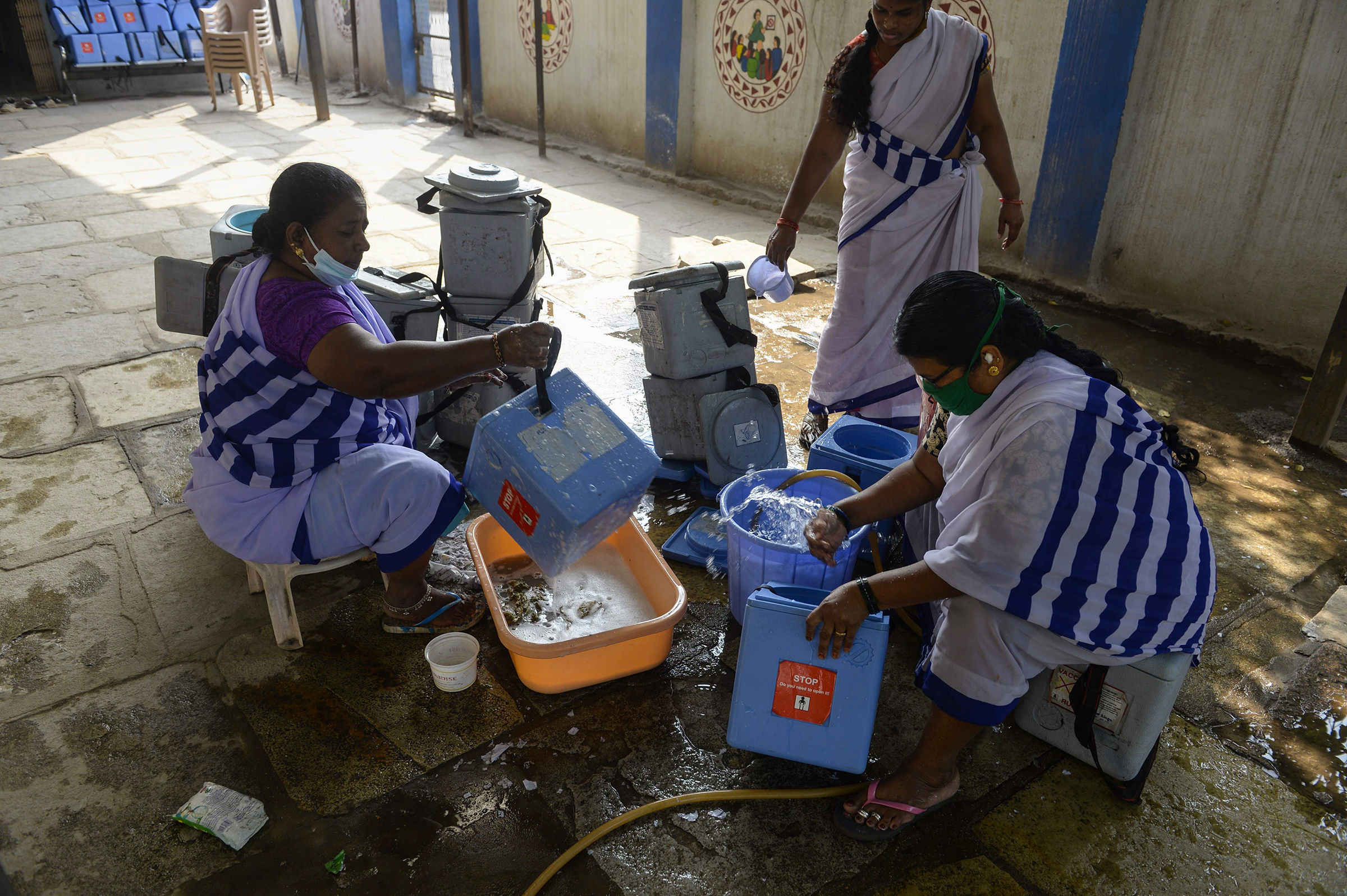 ASHA workers clean carriers for the Covid-19 vaccine at a primary health centre in Hyderabad on January 29.