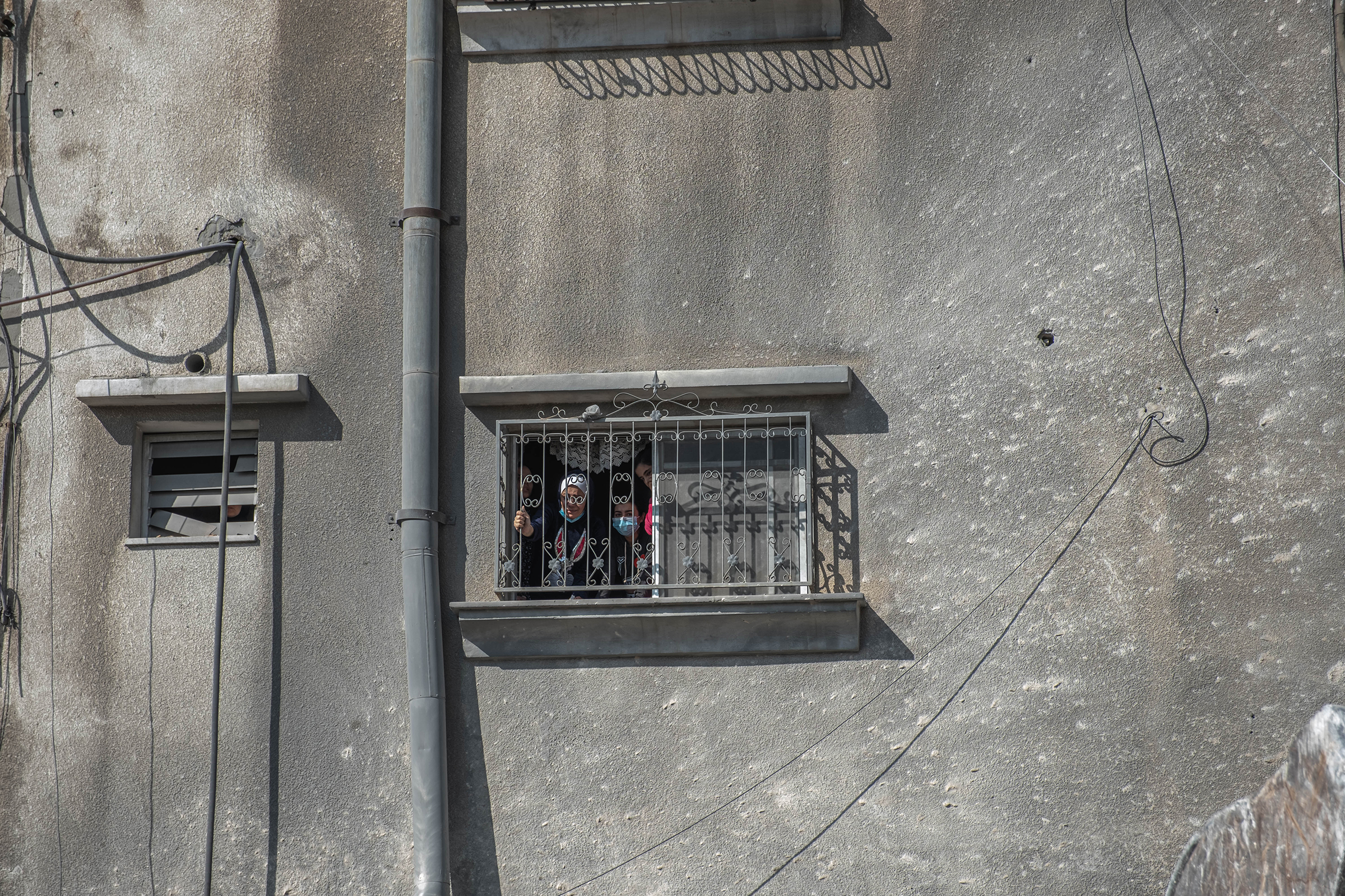 Palestinian women look out from a window at the rubble of a destroyed house in Gaza City on May 16, 2021.