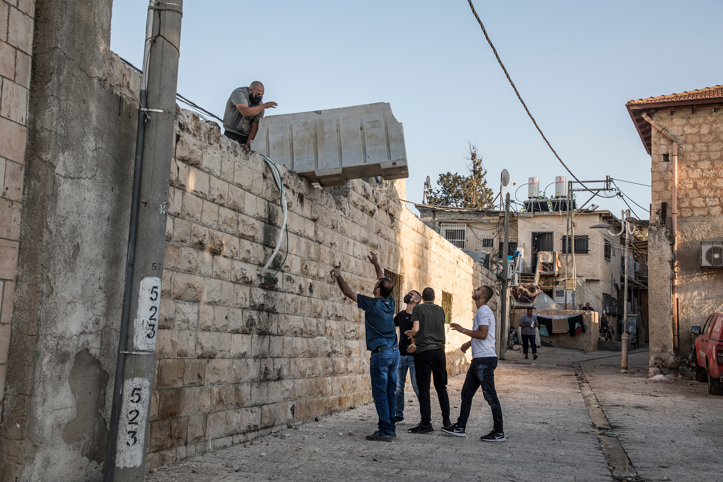 At the mosque in the old city center of Lod, young Palestinians gather on the roof to prepare their defense before expected clashes on May 12, 2021.