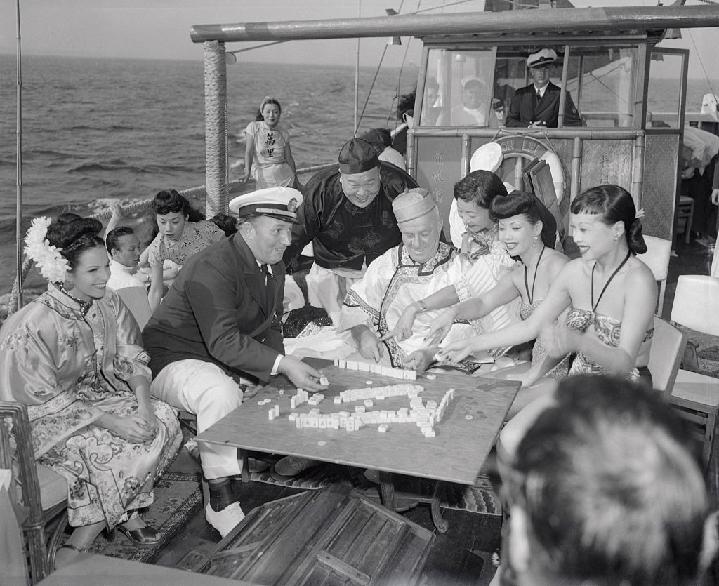 Robert L. Ripley (seated, in captain’s hat) and various guests enjoy a game of mah-jongg aboard the Mon Lei, a junk (type of Chinese sailing ship) he brought across the Pacific from Kowloon, on a cruise on the Long Island Sound in Aug. 1946. Ripley was known for his eponymous show "Believe it or Not!" which featured "unusual" facts from around the world. (Bettmann Archive—Getty Images)