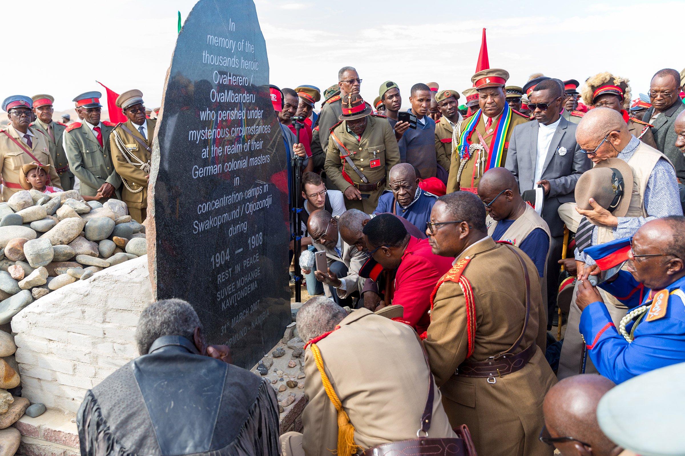 Paramount Chief Adv. Vekuii Rukoro, high-ranked chiefs and other members of the Herero and Nama communities gather around a monument in honor of the Ovaherero and Nama people that were victims of the genocide by German colonial forces at the Swakopmund Concentration Camp Memorial, in Swakopmund, Namibia, as a part of the Reparation Walk 2019 on March 30, 2019. (Christian Ender—Getty Images)