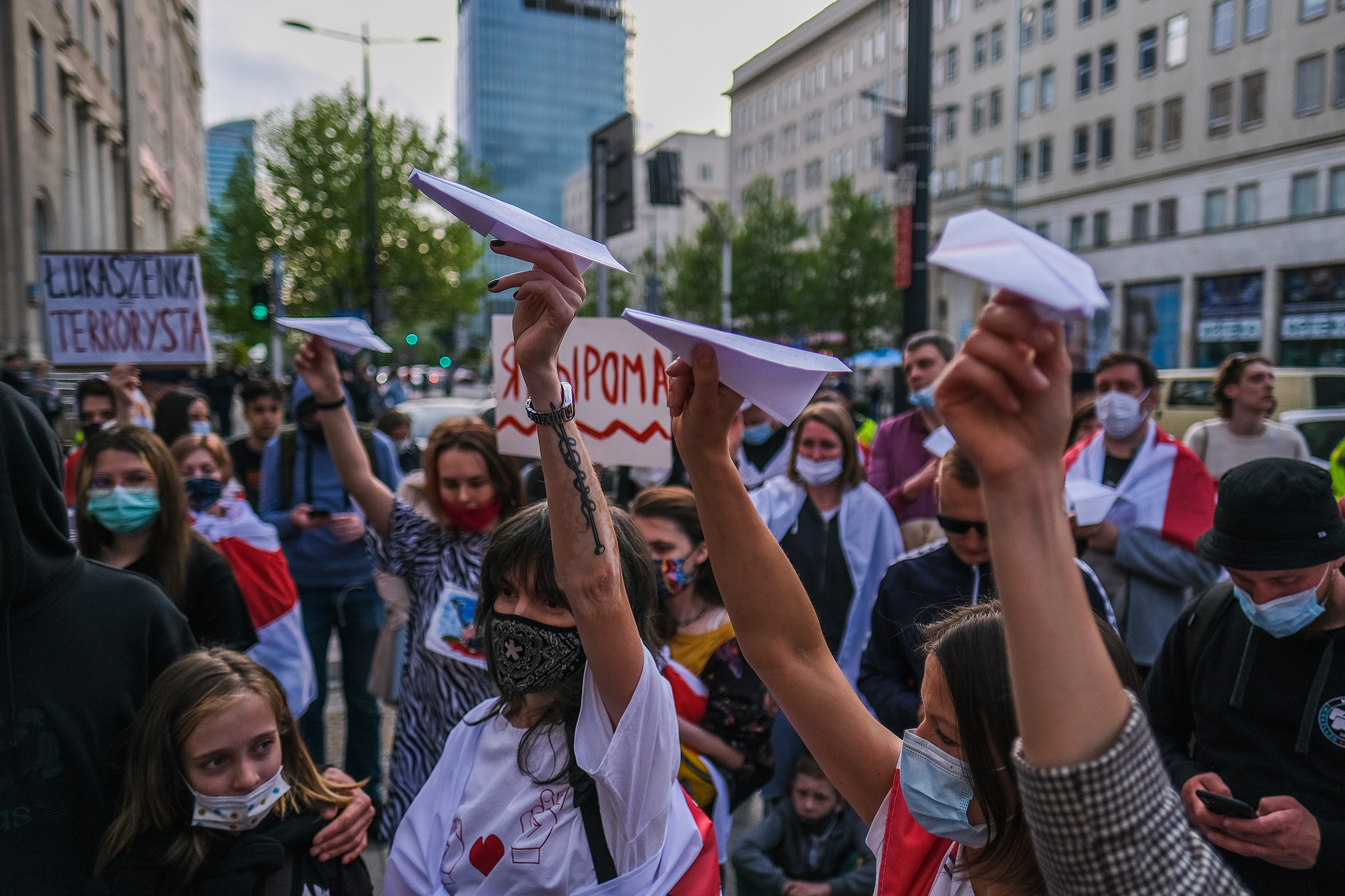 People hold paper airplanes during a protest against the detention of the Belarusian journalist Roman Protasevich in Warsaw on May 24, 2021.