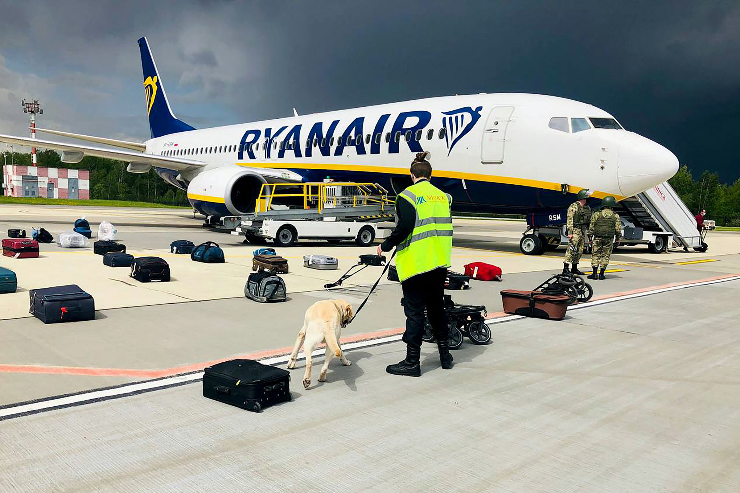 A Belarusian dog handler checks luggage after the Ryanair flight landed in Minsk on May 23, 2021.