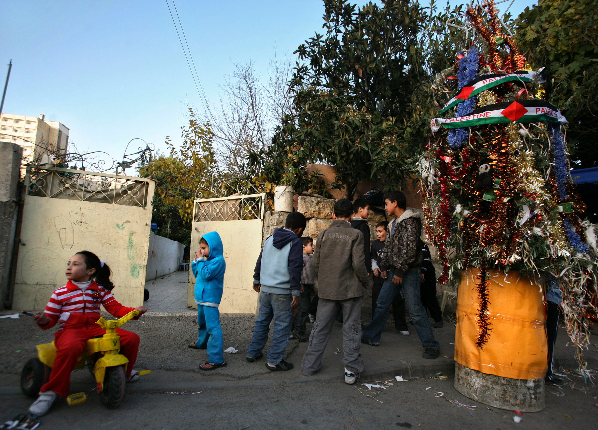 Palestinians gather around a Christmas Tree during a ceremony in the East Jerusalem neighborhood of Sheikh Jarrah on Dec. 23, 2009.