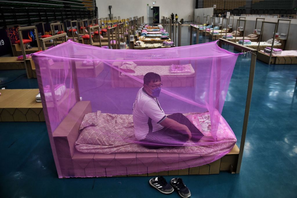 A Bangkok Metropolitan Administration worker tests a bed for incoming COVID-19 coronavirus patients at a new field hospital in a sports stadium on the outskirts of Bangkok on April 18, 2021. (Lillian Suwarnumpha—AFP/Getty Images)