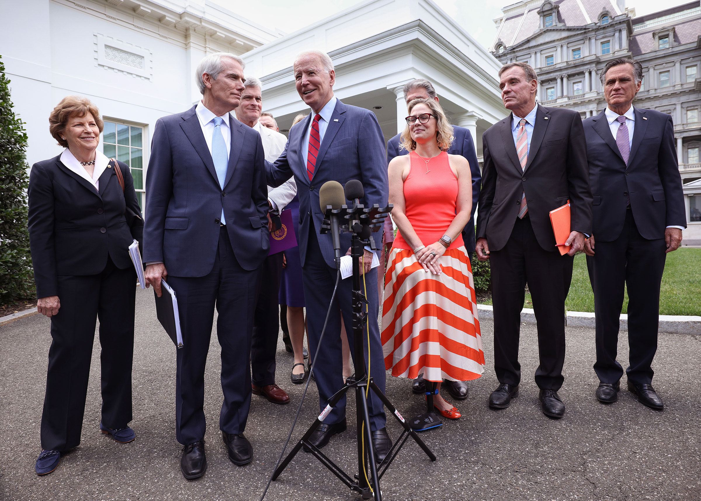 President Joe Biden (C), joined by from left to right, Sen Jeanne Shaheen (D-NH), Sen. Rob Portman (R-OH), Sen Bill Cassidy (R-LA), Sen. Kyrsten Sinema (D-AZ), Sen. Mark Warner (D-VA) and Sen Mitt Romney (R-UT), speaks after the bipartisan group of Senators reached a deal on an infrastructure package at the White House on June 24, 2021 in Washington, DC. Biden said both sides made compromises on the nearly $1 trillion infrastructure bill. (Photography by Kevin Dietsch—Getty Images)