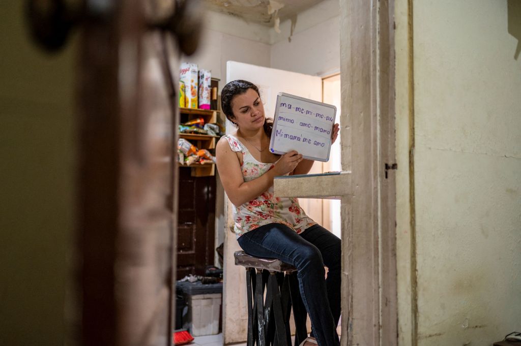 Gabriela Fajardo holds up a white board during an online class she teaches from her home in Matamoros, Mexico, on May 25, 2021. (Sergio Flores—AFP/Getty Images)