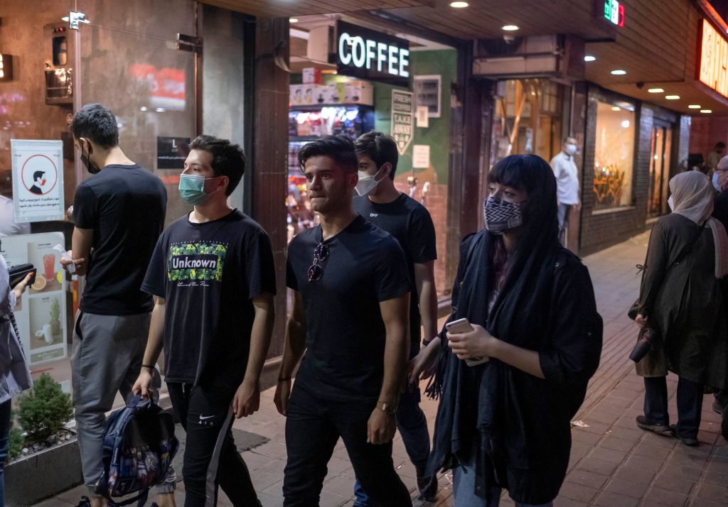 Young Iranians walk along a street in northern Tehran on June 16, 2021 (Morteza Nikoubazl—AFP via Getty Images)