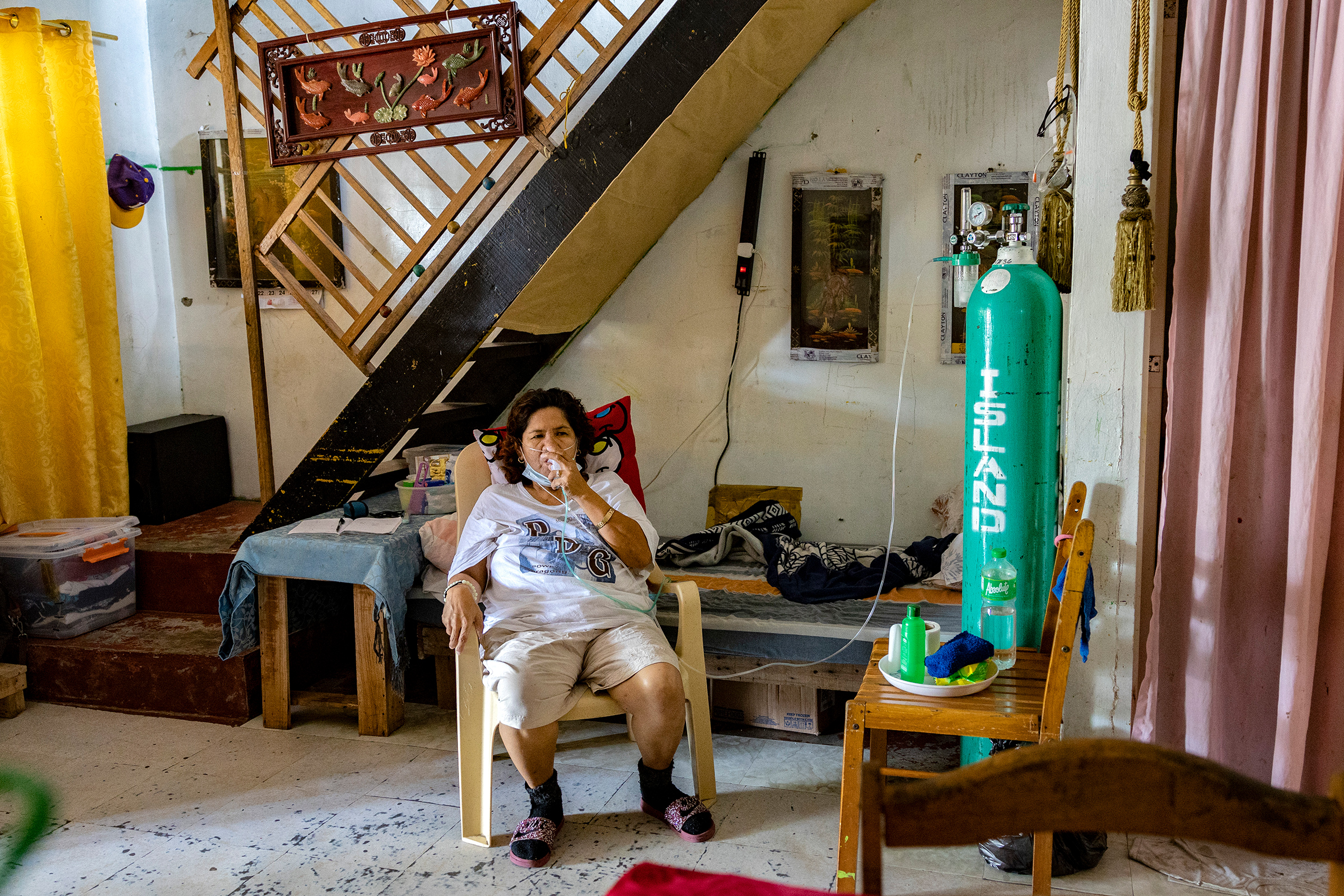 Violeta Bahit, who has COVID-19, breathes with the assistance of an oxygen tank in her home in Lipa, in the province of Batangas, Philippines, on April 9, 2021.
