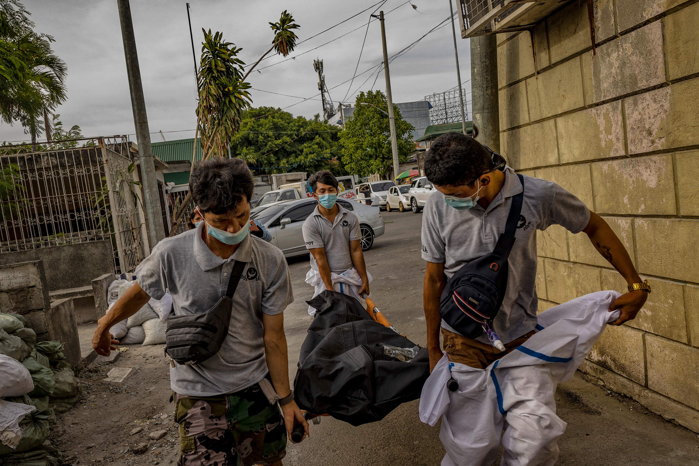 Funeral workers carry the corpse of a COVID-19 victim at a public crematorium in Pasay, Metro Manila, on April 21. (Ezra Acayan—Getty Images)