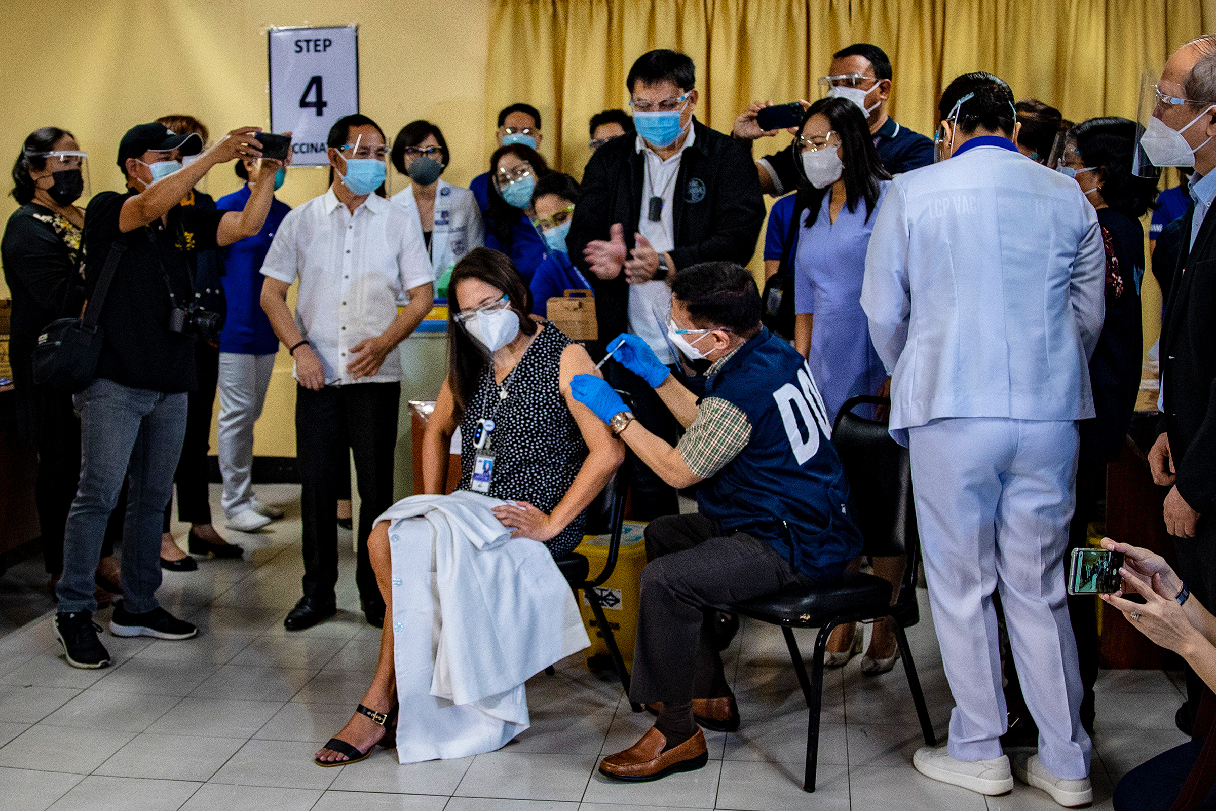 Health Minister Francisco Duque III administers a shot of Sinovac Biotech's CoronaVac vaccine on a health care worker during the first day of COVID-19 vaccinations at the Lung Center of the Philippines Hospital in Quezon City on March 1.