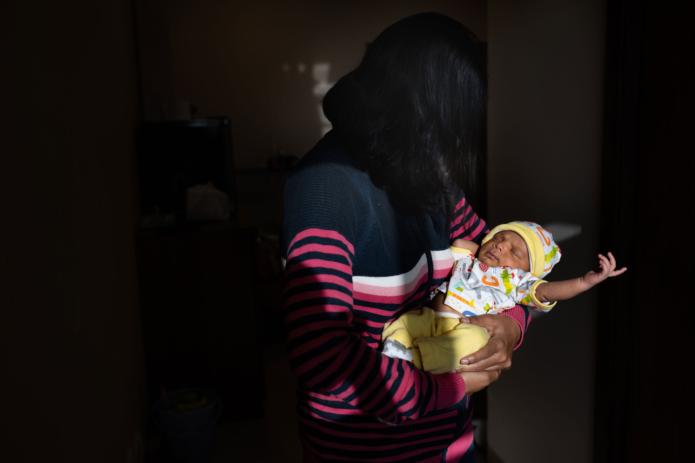 Pooja, who asked TIME to withhold her last name, carries her two-week-old son born through surrogacy at the Akanksha Hospital. She is an Indian citizen but lives in the U.S. with her husband. "The pandemic helped in keeping our surrogacy a secret with our friends in the U.S.," Pooja says. "We told everyone that I was pregnant and have now announced that we had a baby." (Smita Sharma for TIME)