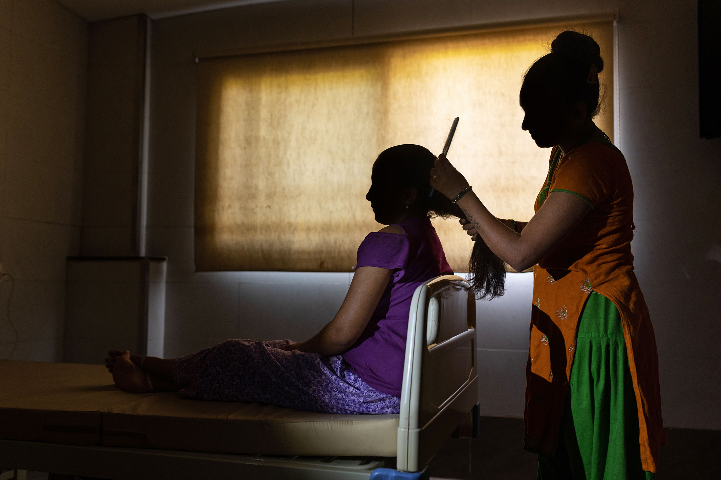 First-time surrogate Heena Sodaparmar combs the hair of Neha Makwana, who is at Akanksha for the second time to save money for her family.