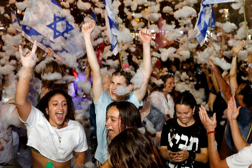 Israeli demonstrators celebrate the passing of a Knesset vote confirming a new coalition government during a rally in Tel Aviv on June 13, 2021. (Jack Guez—AFP/Getty Images)