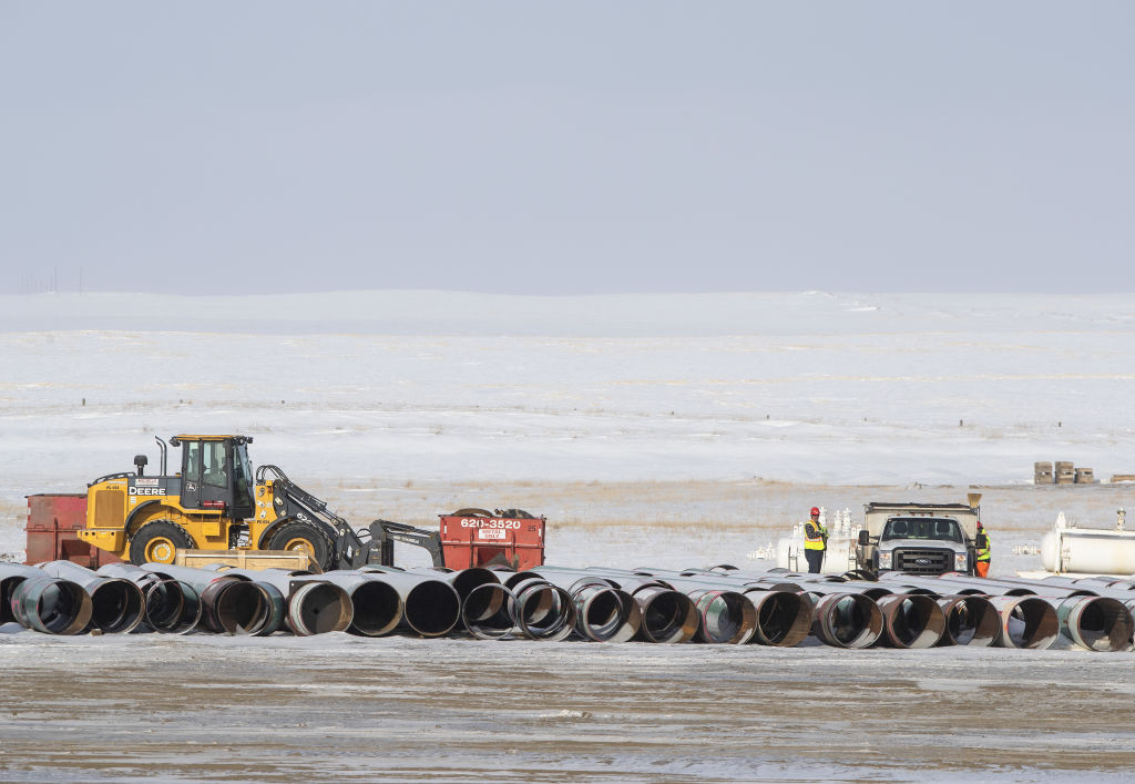 Workers load a truck with equipment at a pipe yard for the Keystone XL pipeline in Oyen, Alberta, Canada, on Tuesday, Jan. 26, 2021. U.S. President Joe Biden revoked the permit for TC Energy's Keystone XL energy pipeline via executive order hours after his inauguration, the clearest sign yet that constructing a major new pipeline in the U.S. has become an impossible task. (Jason Franson–Bloomberg/Getty Images)