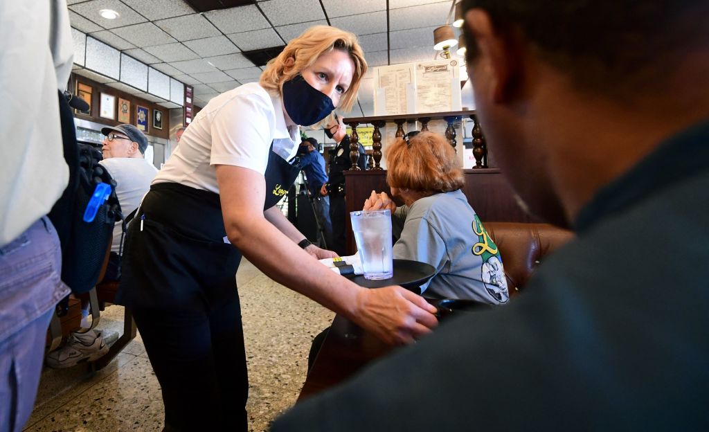 a waitress wears a face mask while serving at Langer's Delicatessen-Restaurant in Los Angeles, California
