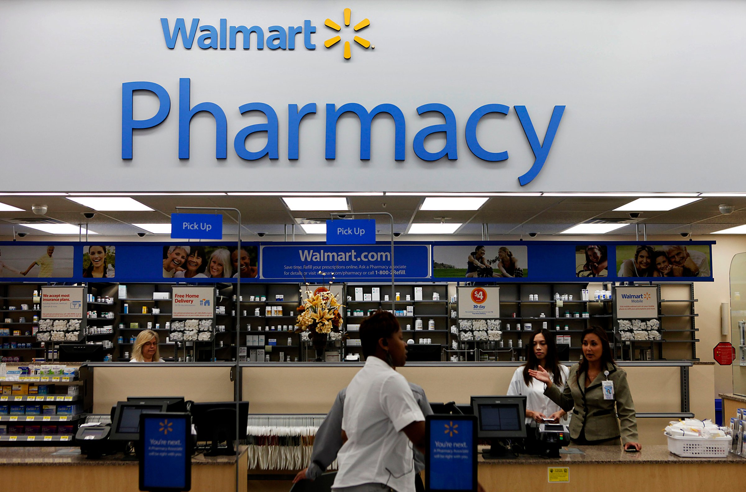 A customer walks past the pharmacy during the grand opening of a new Wal-Mart Stores Inc. location in Torrance, California, U.S., on Wednesday, Sept. 12, 2012