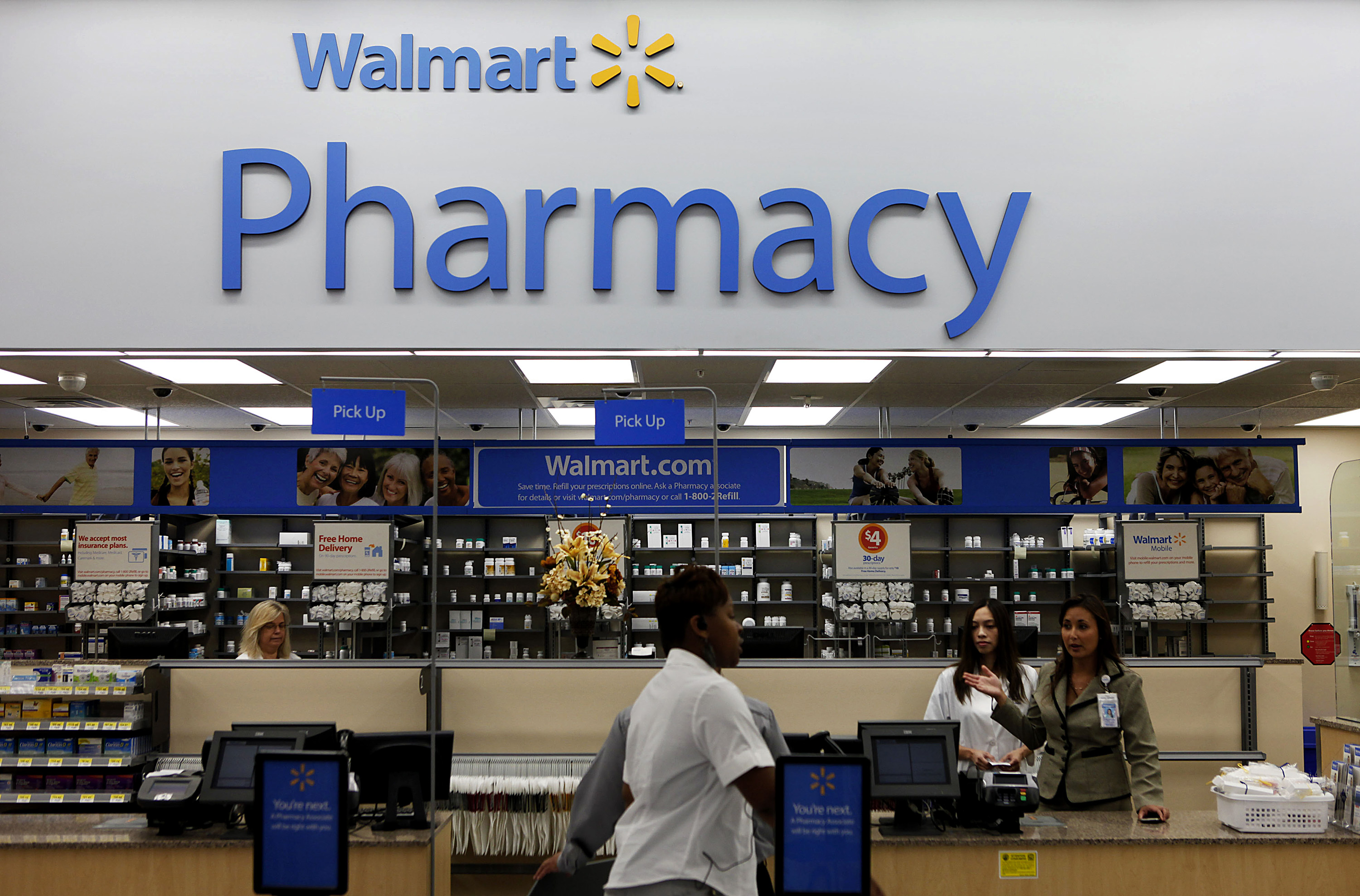 A customer walks past the pharmacy during the grand opening of a new Wal-Mart Stores Inc. location in Torrance, California, U.S., on Sept. 12, 2012. (Patrick Fallon—Bloomberg/Getty Images)