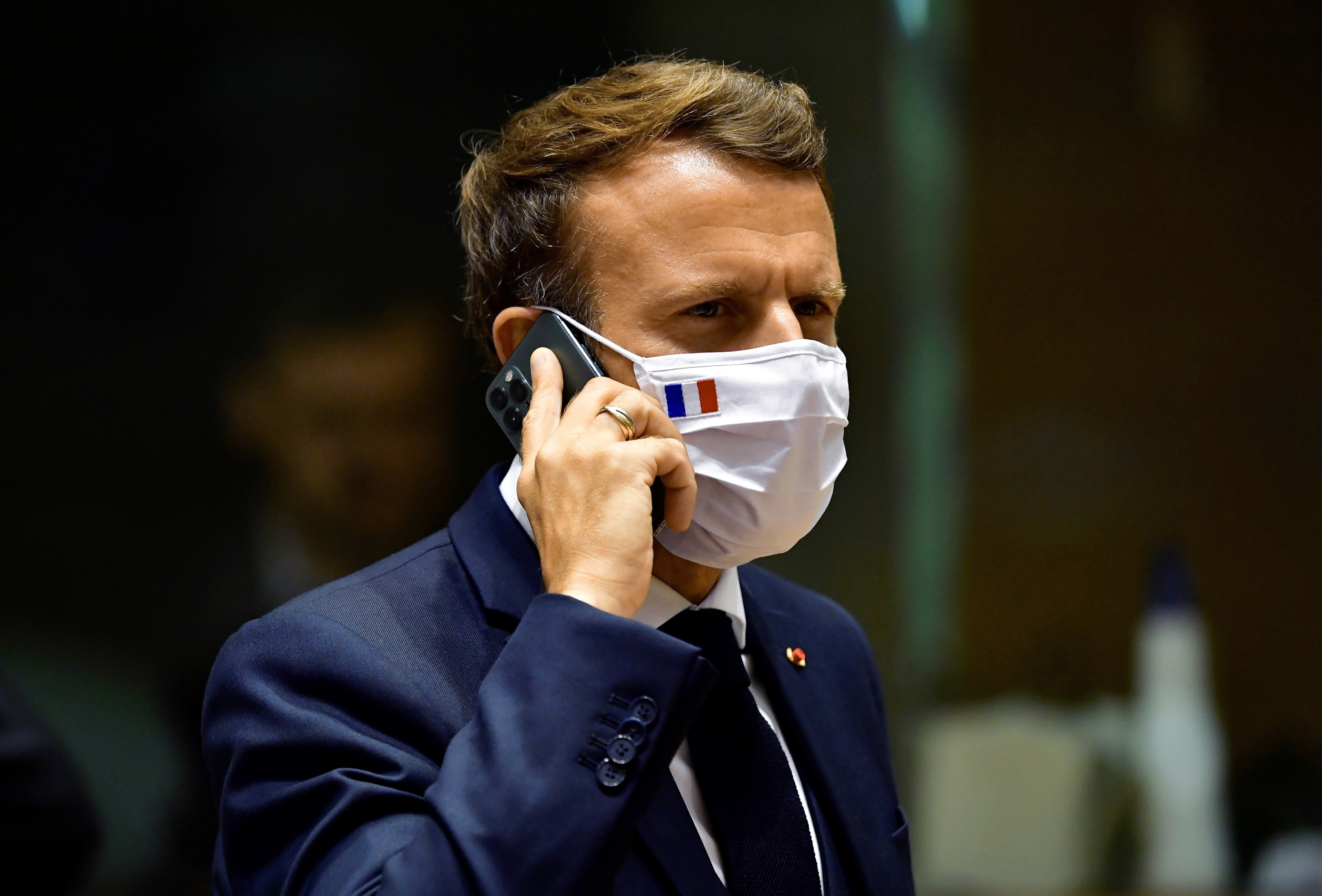 French President Emmanuel Macron speaks on his mobile phone during a round table meeting at an EU summit in Brussels on July 20, 2020. (John Thys—AP)