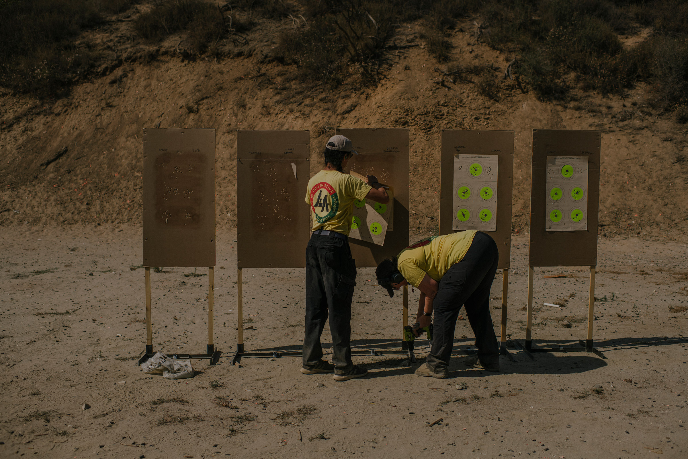 Tom Nguyen and Robbie Tarnove of L.A. Progressive Shooters, a group that works to empower BIPOC gun owners, remove targets after a beginner’s class at Burro Canyon Shooting Park in Azusa, CA. (Isadora Kosofsky for TIME)
