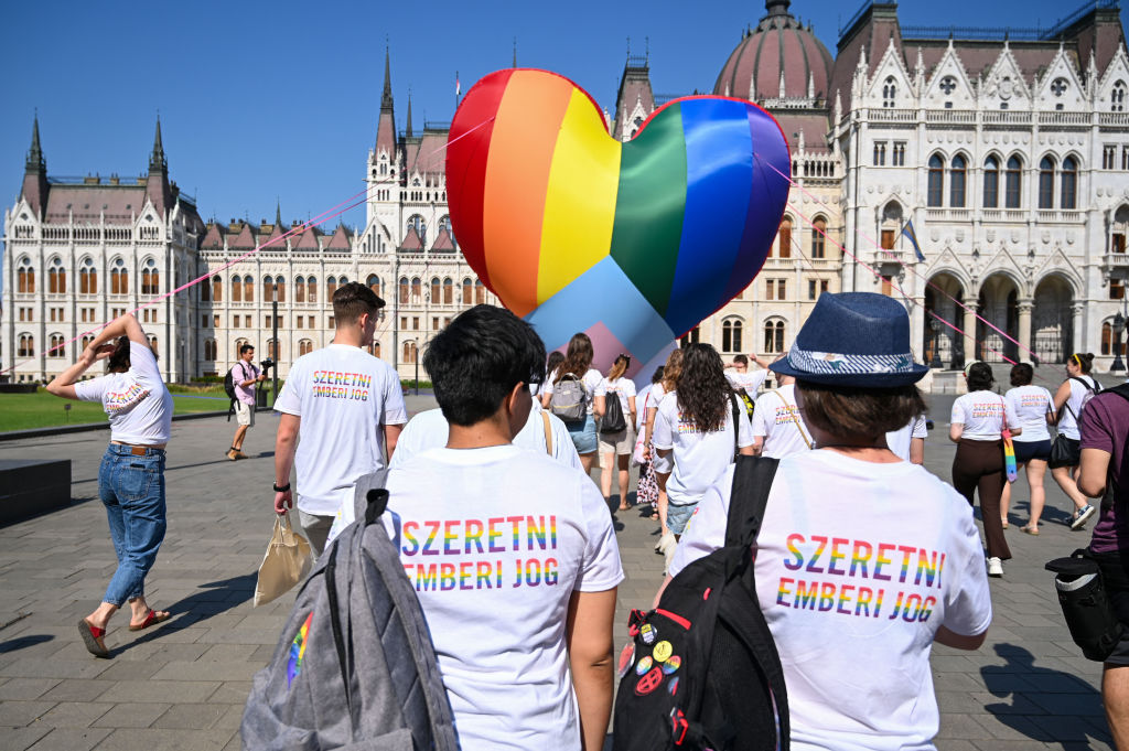 Activists wear shirts reading "Love is a human right" as they fly a giant heart balloon in rainbow colors during a flashmob in order to protest against a new law in front of the parliament in Budapest on July 8, 2021. - A Hungarian anti-paedophilia bill that came into force on July 8, 2021 was condemned as "homophobic" by civil organisations during the protest. The law banning the "display or promotion" of homosexuality or gender change to minors has sparked widespread outcry and threats of sanctions from Brussels if the bill is not rectified. (ATTILA KISBENEDEK—AFP / Getty Images)