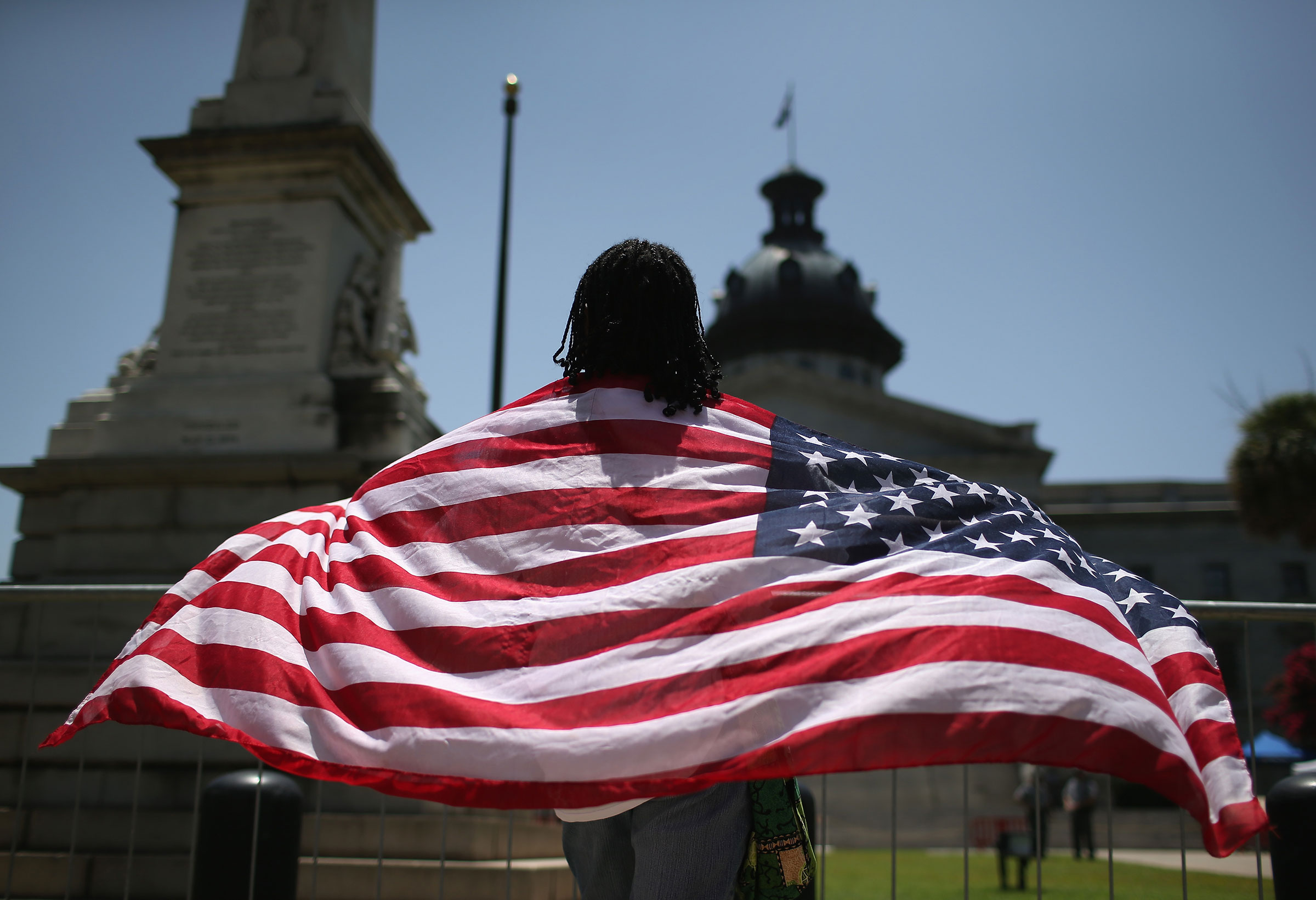 A South Carolinan wears the "Stars and Stripes" after the Confederate "Stars and Bars" was lowered from the flagpole in front of the statehouse on July 10, 2015 in Columbia, South Carolina.