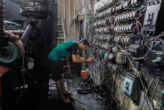 A technician controls an electric switch board connecting homes to privately-owned electricity generators in a suburb of Iraq's capital Baghdad on June 30, 2021 as the national electric grid is experiencing outages amidst a severe heat wave. 