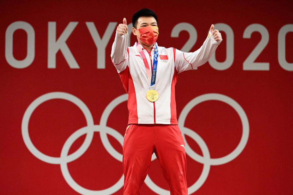 Gold medallist China's Chen Lijun gestures as he stands on the podium for the victory ceremony of the men's 67kg weightlifting competition during the Tokyo 2020 Olympic Games at the Tokyo International Forum in Tokyo on July 25, 2021. (Vincenzo Pinto—AFP via Getty Images)
