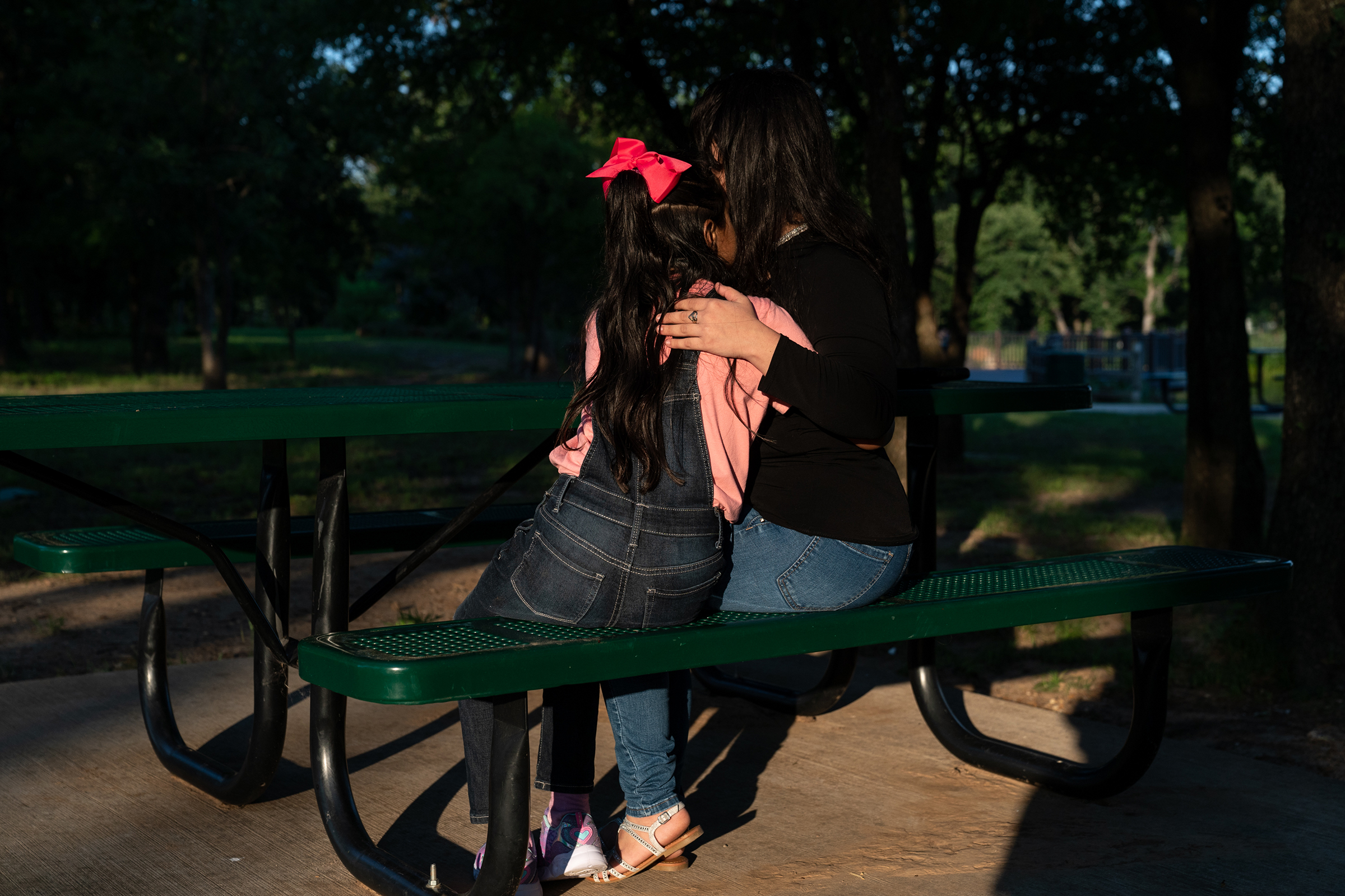 Estefani and her eight-year-old daughter, Ashly, embrace in a park near the home of relatives in June.