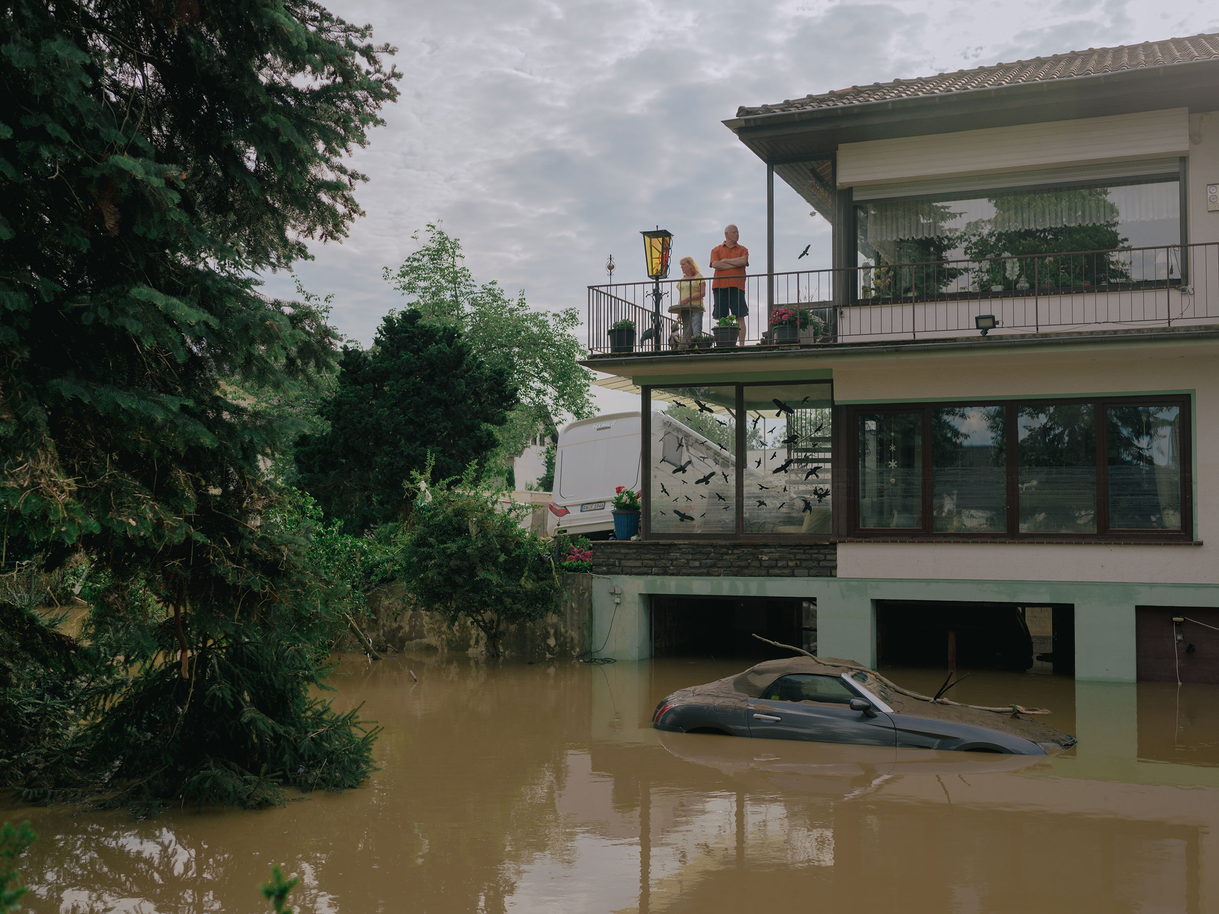 People stand on a balcony above the floodwaters in Ahrweiler, Germany, July 15, 2021. (DOCKS Collective)