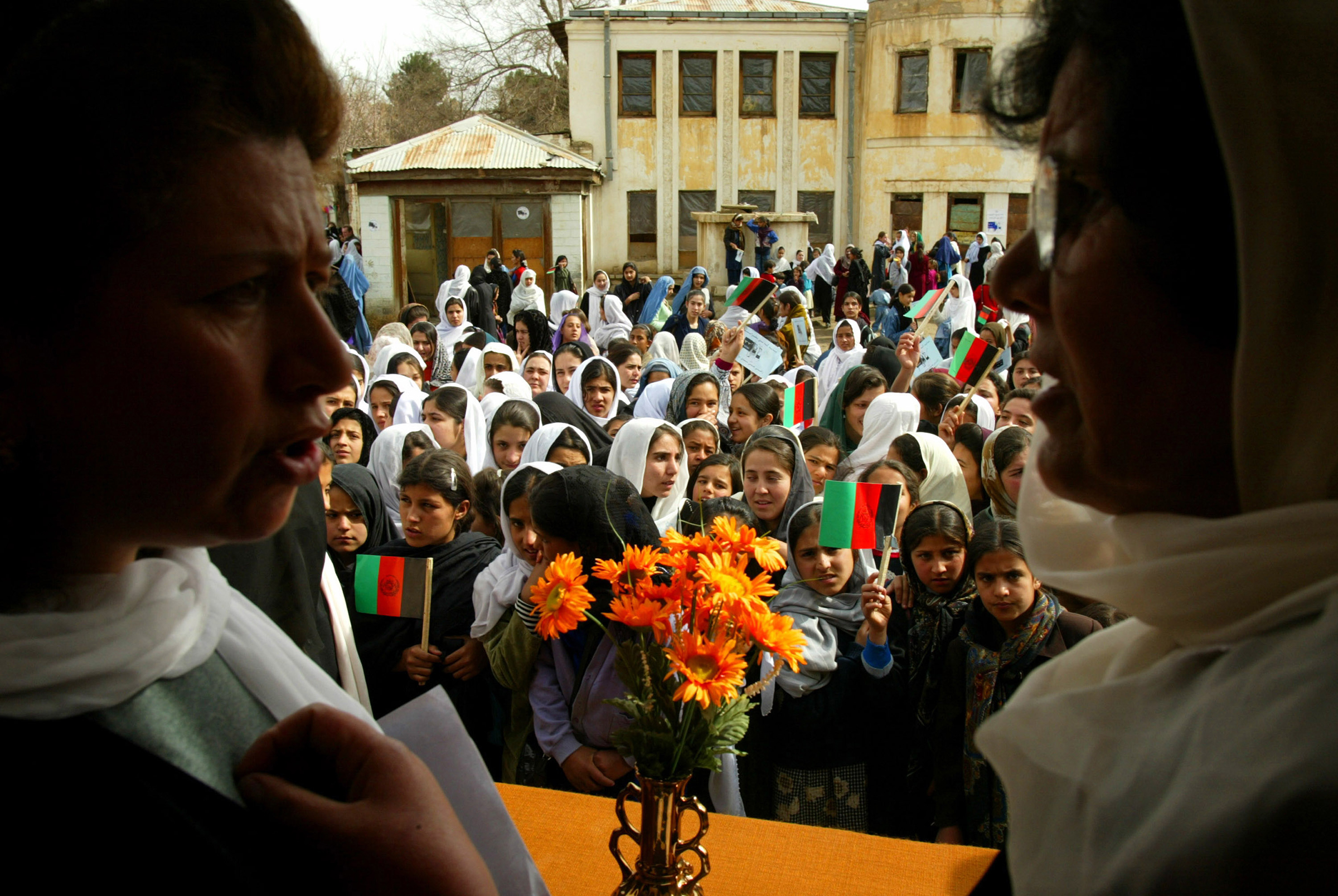 Teachers prepare to organize students into a group for the opening ceremonies on the first day of class at the Manoo Chera school in Kabul on March 23, 2002.