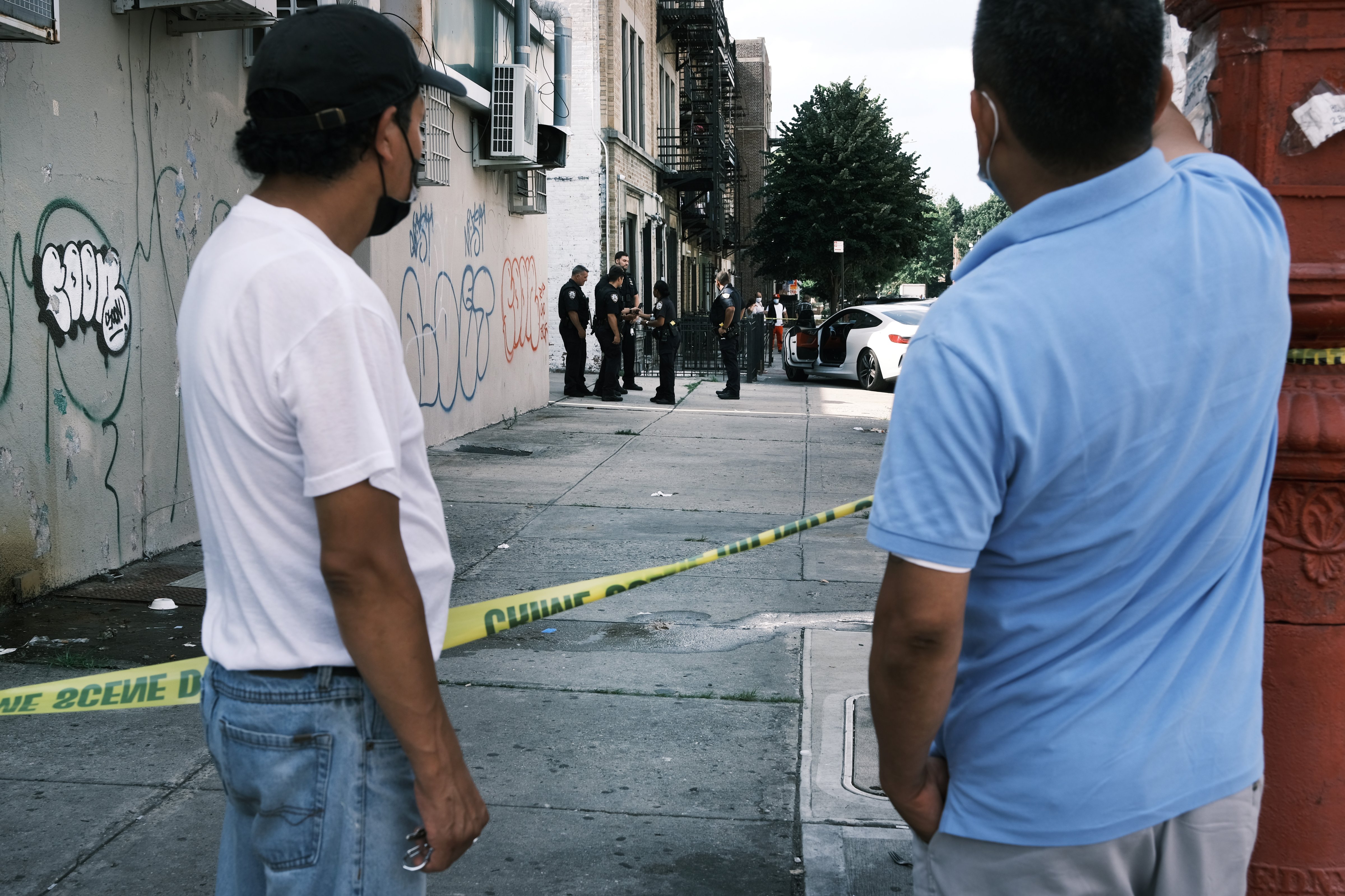 People look on as police converge on the scene of a shooting in Brooklyn, one of numerous during the day, on July 14, 2021 in New York City. (Spencer Platt—Getty Images)