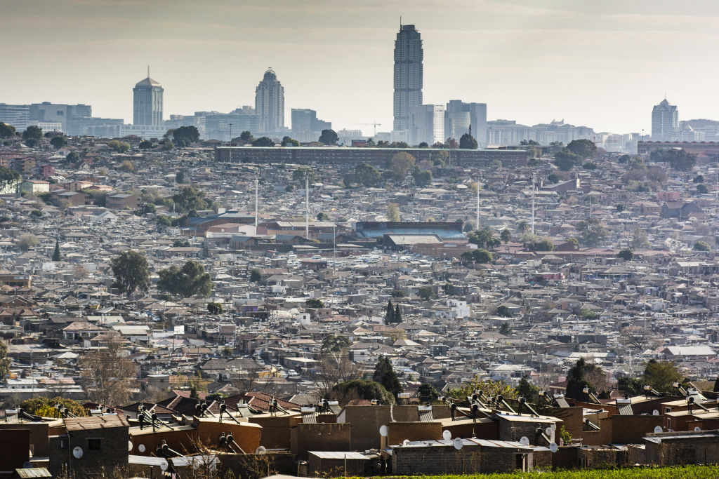 Residential housing stands in the Alexandra township as the skyscraper office buildings in the Sandton area stand on the skyline beyond in Johannesburg, South Africa, on Thursday, June 11, 2020. (Waldo Swiegers — Bloomberg / Getty Images)
