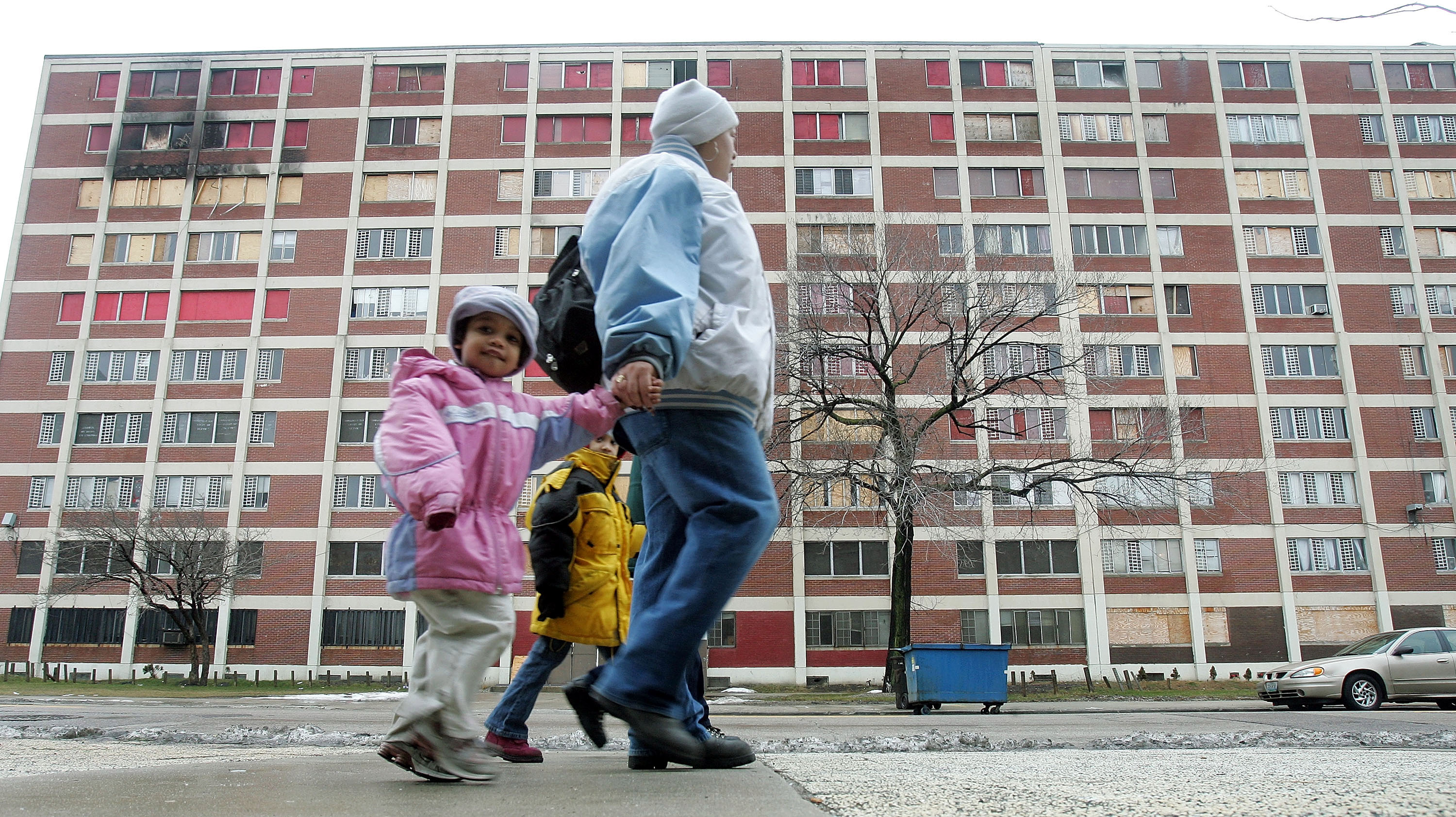 Residents walk past one of the few remaining Chicago Housing Authority Cabrini-Green public housing buildings in 2005. (Tim Boyle/Getty Images)