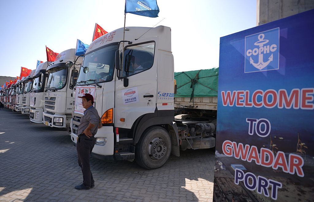 A Chinese worker stands near trucks carrying goods during the opening of a trade project in Gwadar port, some 700 kms west of the Pakistani city of Karachi on November 13, 2016. (AAMIR QURESHI/AFP via Getty Images)