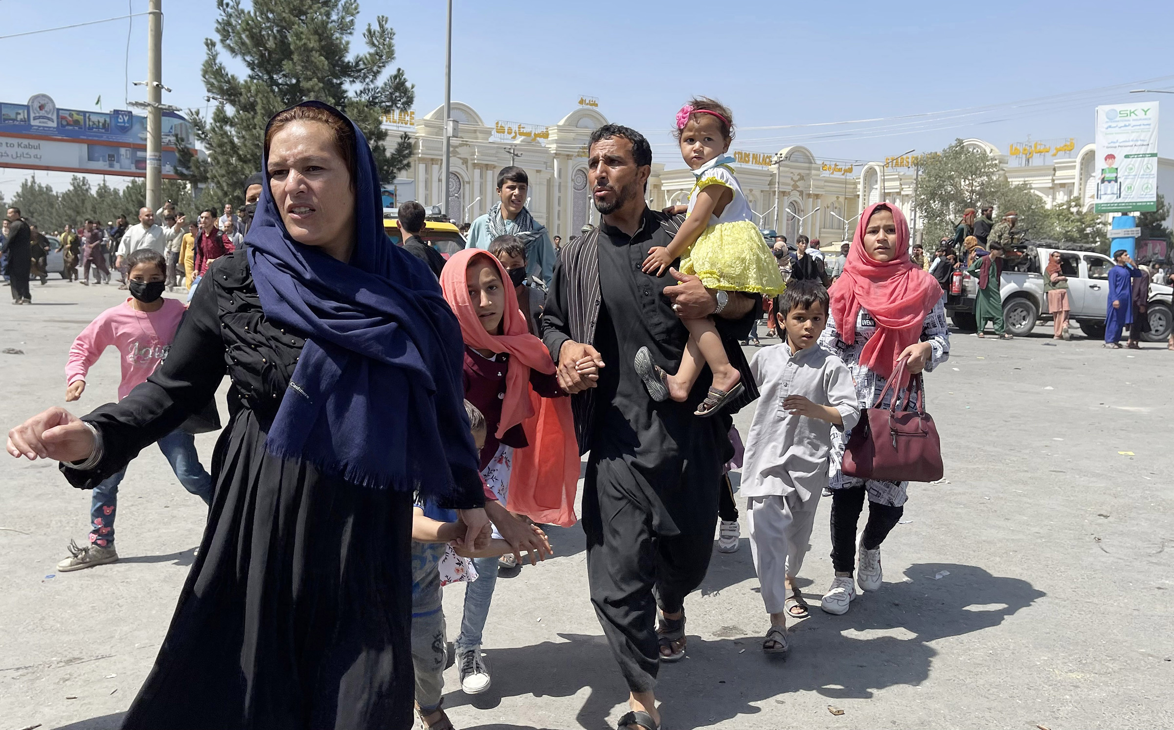 An Afghan family rushes to the Hamid Karzai International Airport as they flee Kabul, Afghanistan, on August 16, 2021. (Haroon Sabawoon—Anadolu Agency/Getty Images)
