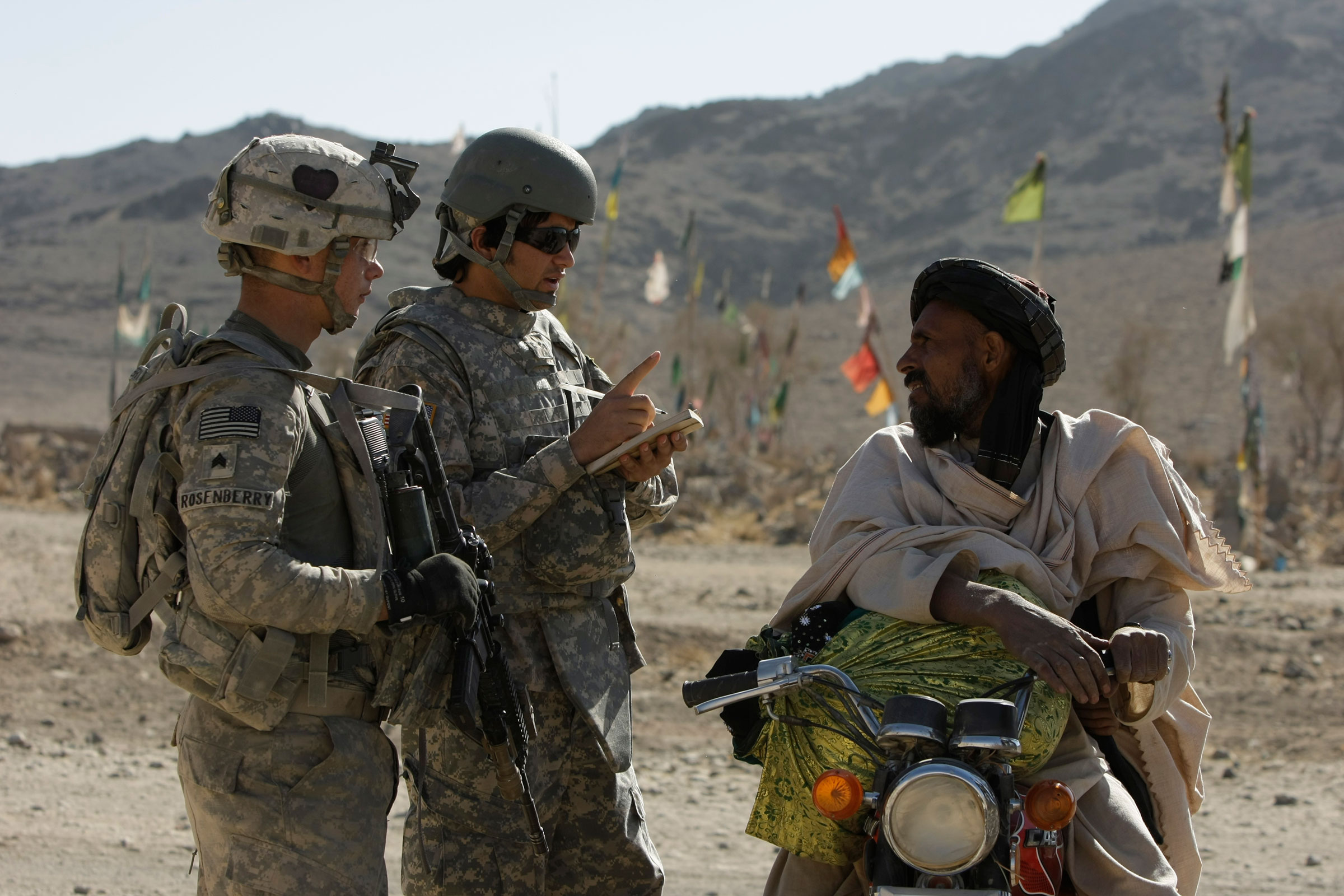 US Army Sgt. Skyler Rosenberry of Pennsylvania, left, and an Afghan interpreter, center, from First Battalion, 502nd Infantry Regiment, 101st Airborne Division speak to an Afghan man during a foot patrol in West Now Ruzi village, district Panjwai, Afghanistan's Kandahar province, Wednesday, Nov. 24, 2010. (Alexander Zemlianichenko—AP)
