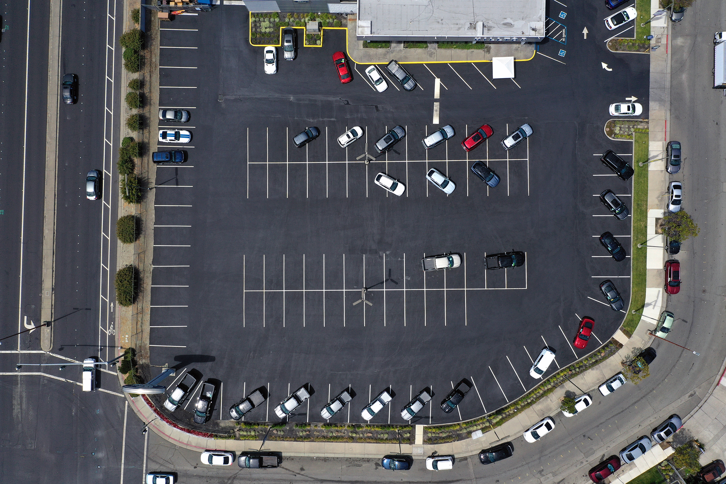 In an aerial view, the sales lot at Hilltop Ford is nearly empty on July 09, 2021 in Richmond, California. The global microchip shortage continues to impact the automobile supply chain and is causing the price of new cars to increase as inventory dwindles. (Justin Sullivan—Getty Images)