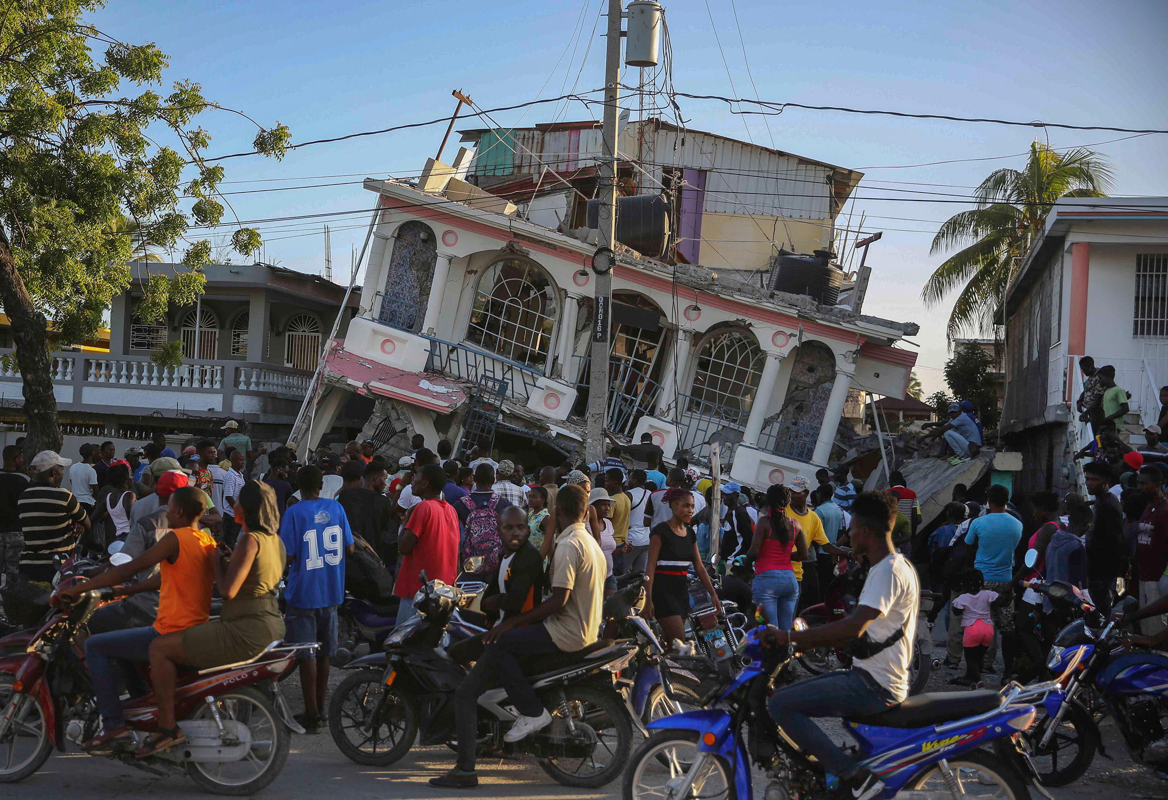 People gather outside the Petit Pas Hotel, destroyed by the earthquake in Les Cayes, on Aug. 14. (Joseph Odelyn—AP)