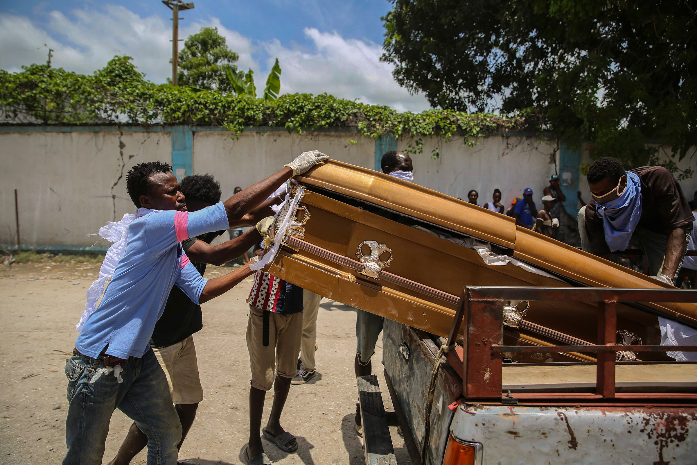 Men load the coffin containing the remains of Francois Elmay, after recovering his body from the rubble of a home, in Les Cayes on Aug. 18. (Joseph Odelyn—AP)