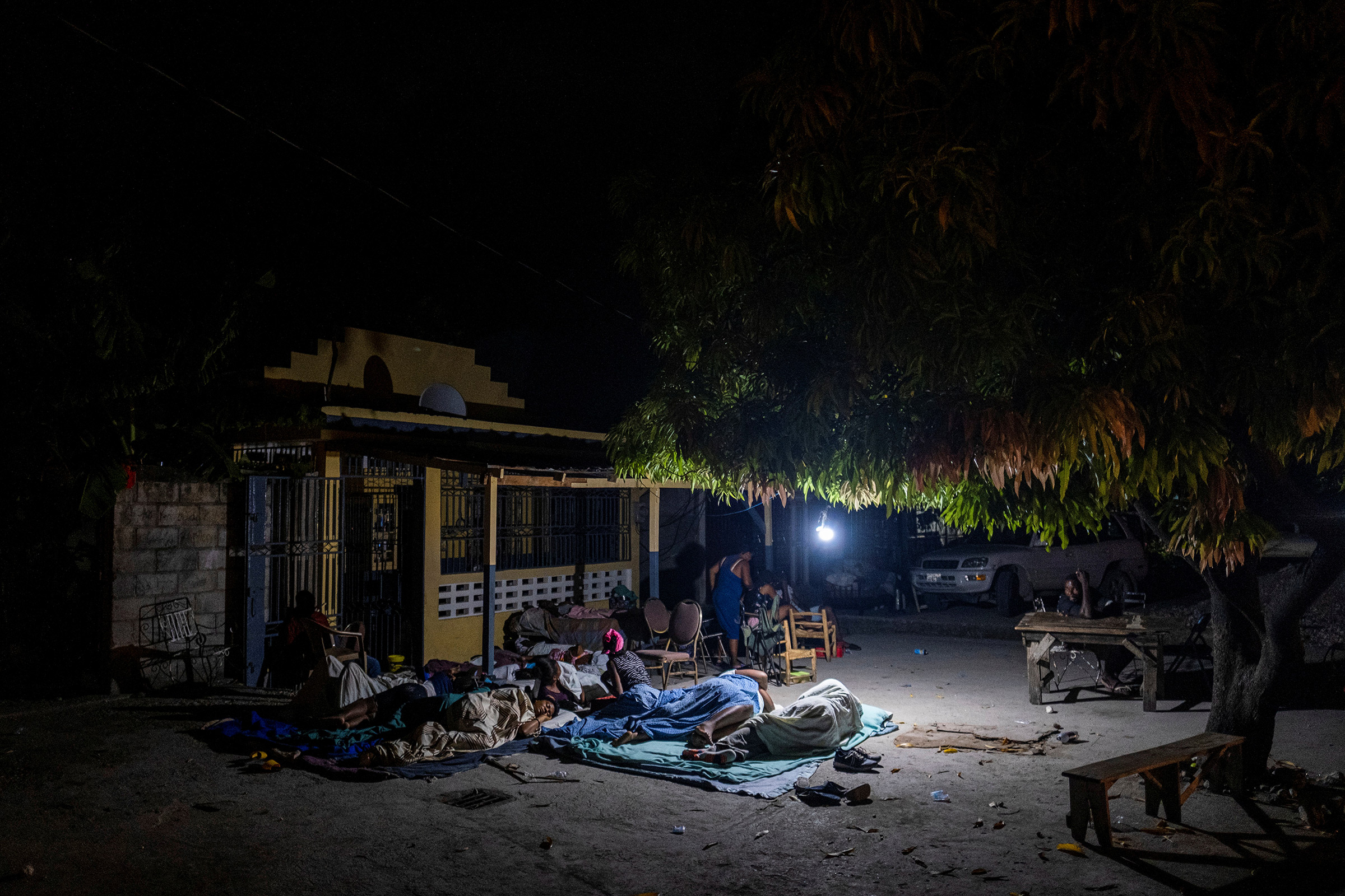 People rest outside their home after tremors shook buildings in Les Cayes on Aug. 19. (Ricardo Arduengo—Reuters)