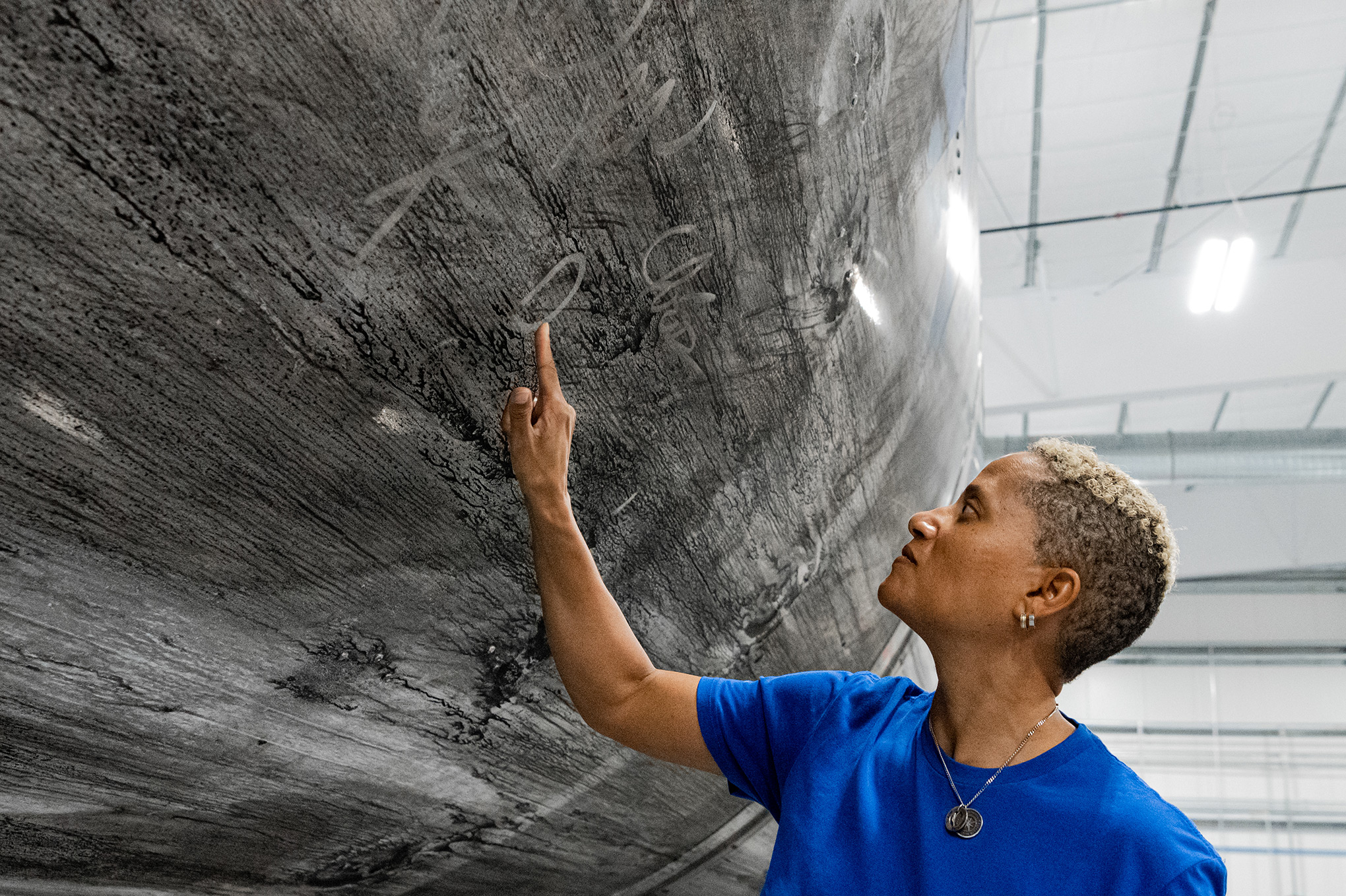 Dr. Sian Proctor signing the Falcon 9 reusable rocket booster that will launch the Inspiration4 crew into space. It has become a new tradition for SpaceX crews to sign their reusable vehicles. (John Kraus—Inspiration4)