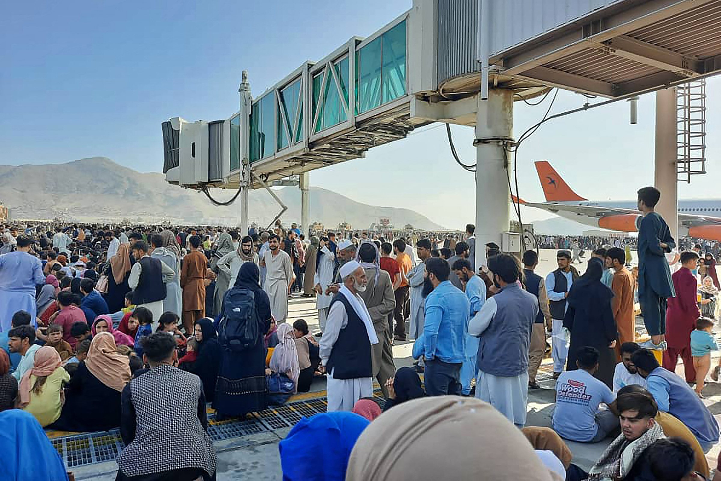 Afghans fleeing the Taliban's arrival in Kabul crowd the tarmac of the airport on Aug. 16, 2021.
