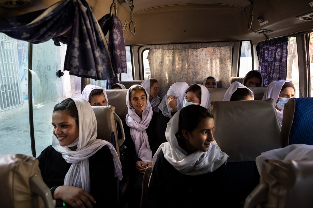 Girls ride in a school bus after classes at the Zarghoona high school in Kabul on July 25, 2021. The school reopened after a nearly two-month break due to the coronavirus pandemic.
