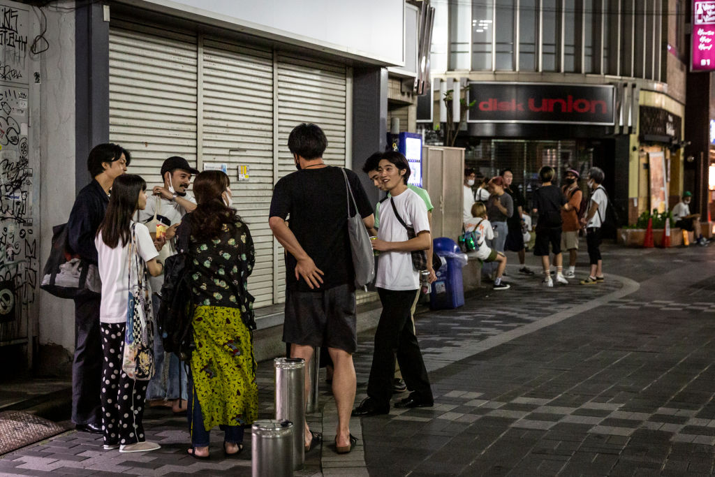 People stand in the street and drink on August 5, 2021 in Tokyo, Japan. (Yuichi Yamazaki—Getty Images)