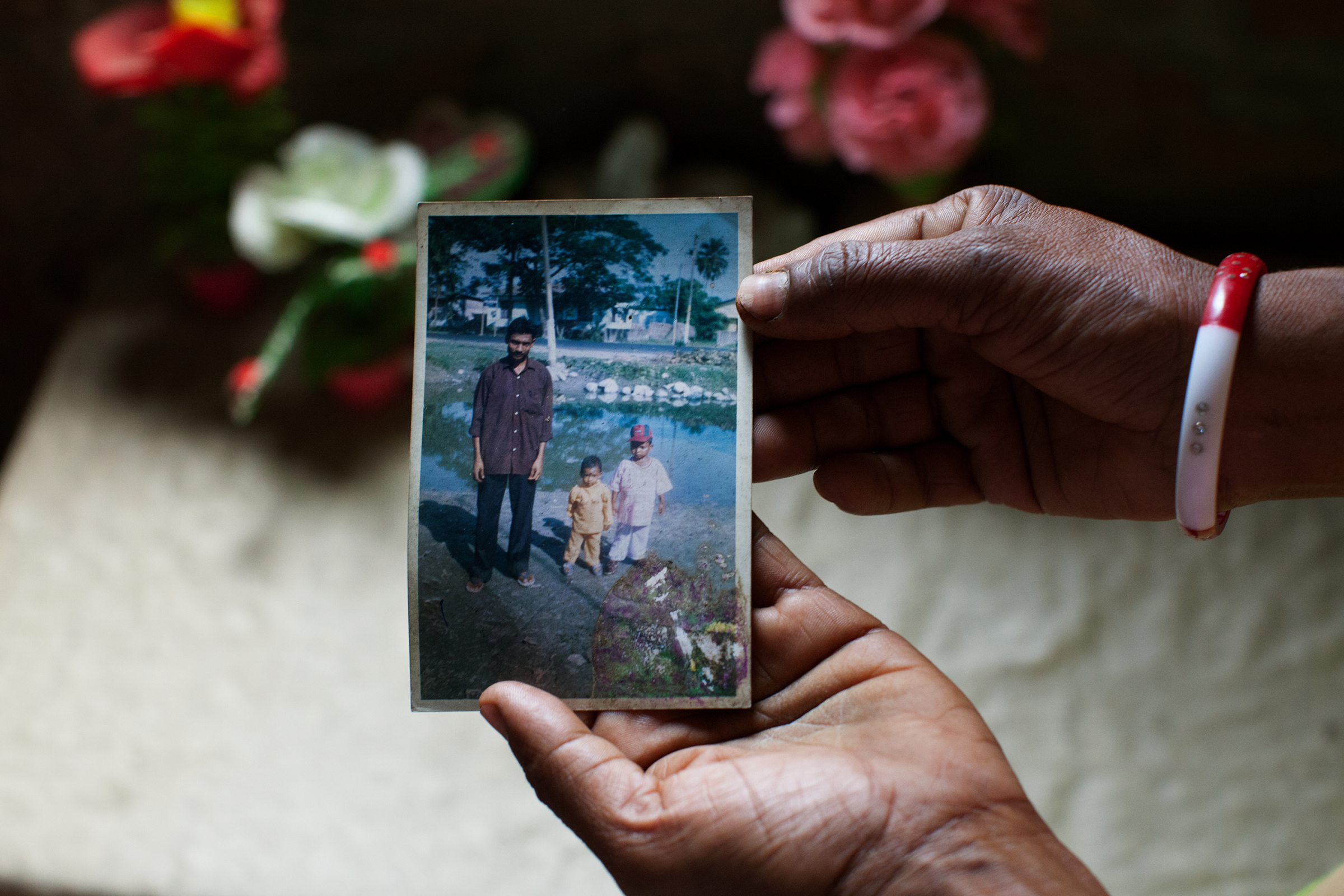 Mamtaj Begum holds a photograph of her husband, Mahuruddin, who is held in a detention center in Tezpur. Mahuruddin was photographed with his son and nephew.