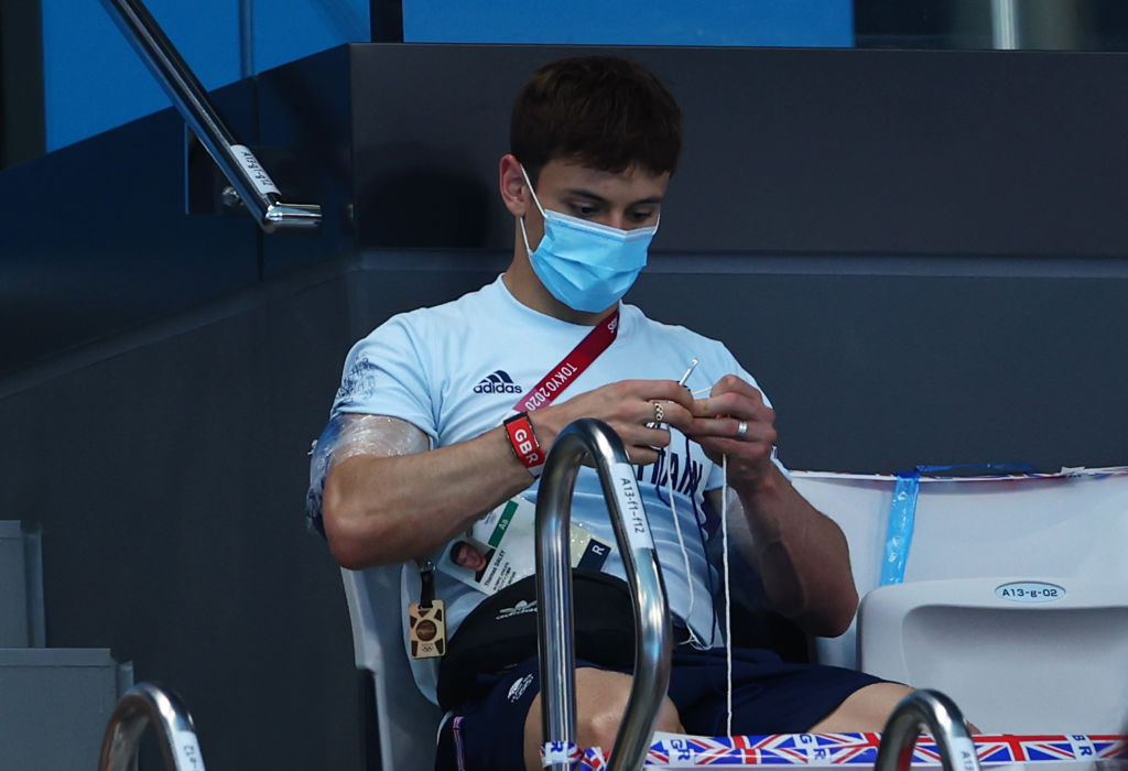 Tom Daley of Team Great Britain is seen knitting in the stands during the men's 3-m springboard final on day eleven of the Tokyo 2020 Olympic Games at Tokyo Aquatics Centre on Aug. 03, 2021 in Tokyo, Japan. (Clive Rose—Getty Images)