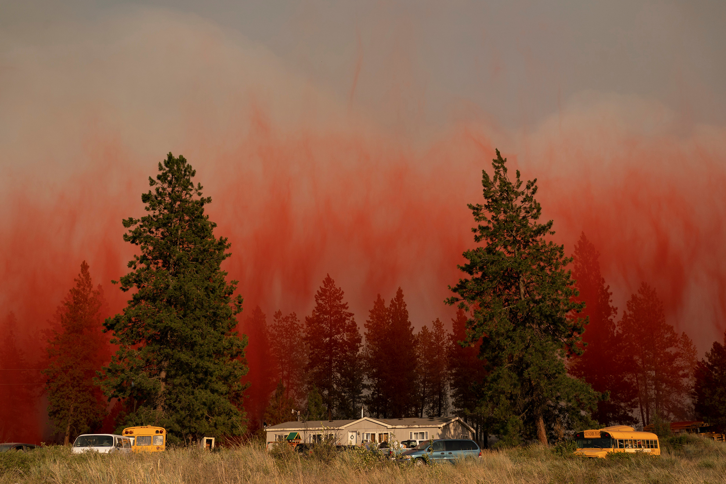 Fire retardant dropped from an airplane falls to the ground near the Chuweah Creek Fire as wildfires devastate Nespelem, Wash. on July 14. (David Ryder—Reuters)